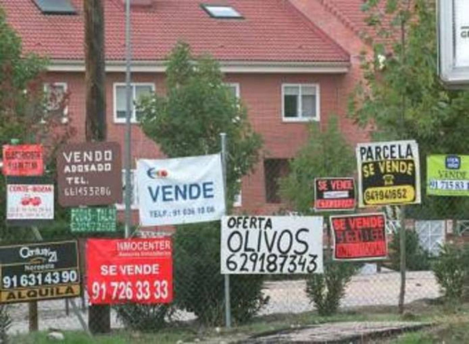 Carteles de venta de viviendas sobre una valla