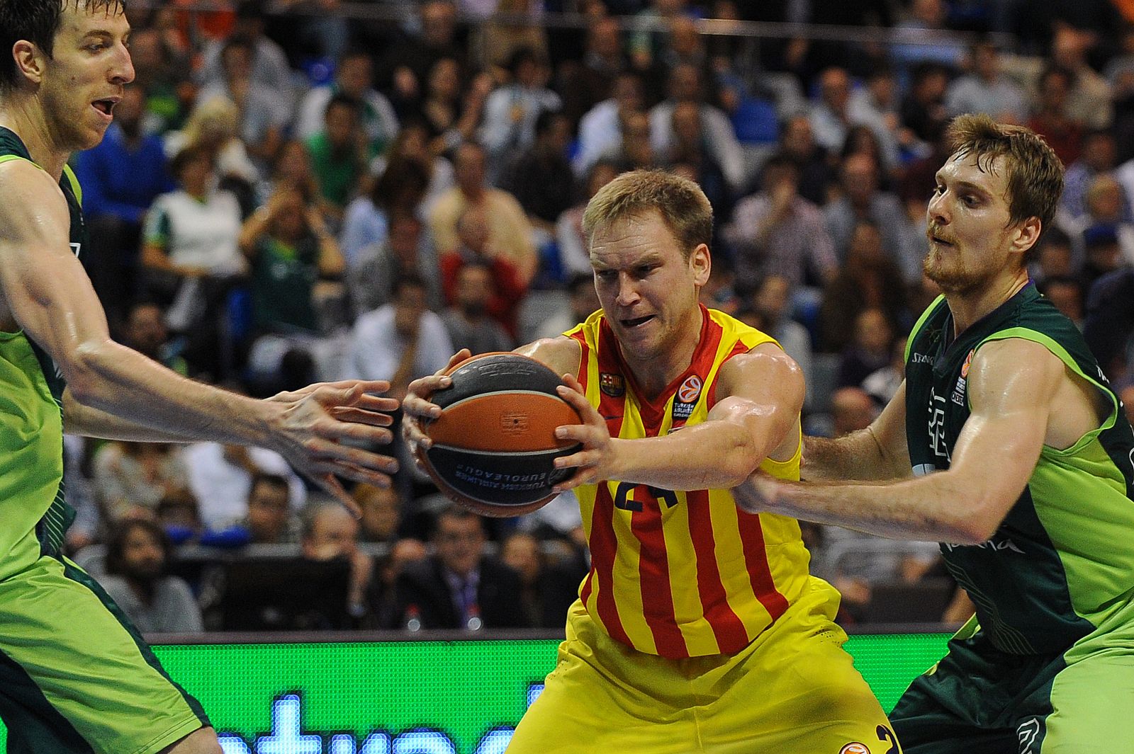 Fran Vazquez y Zoran Dragic tratan de robar el balón a Brad Oleson durante el partido.