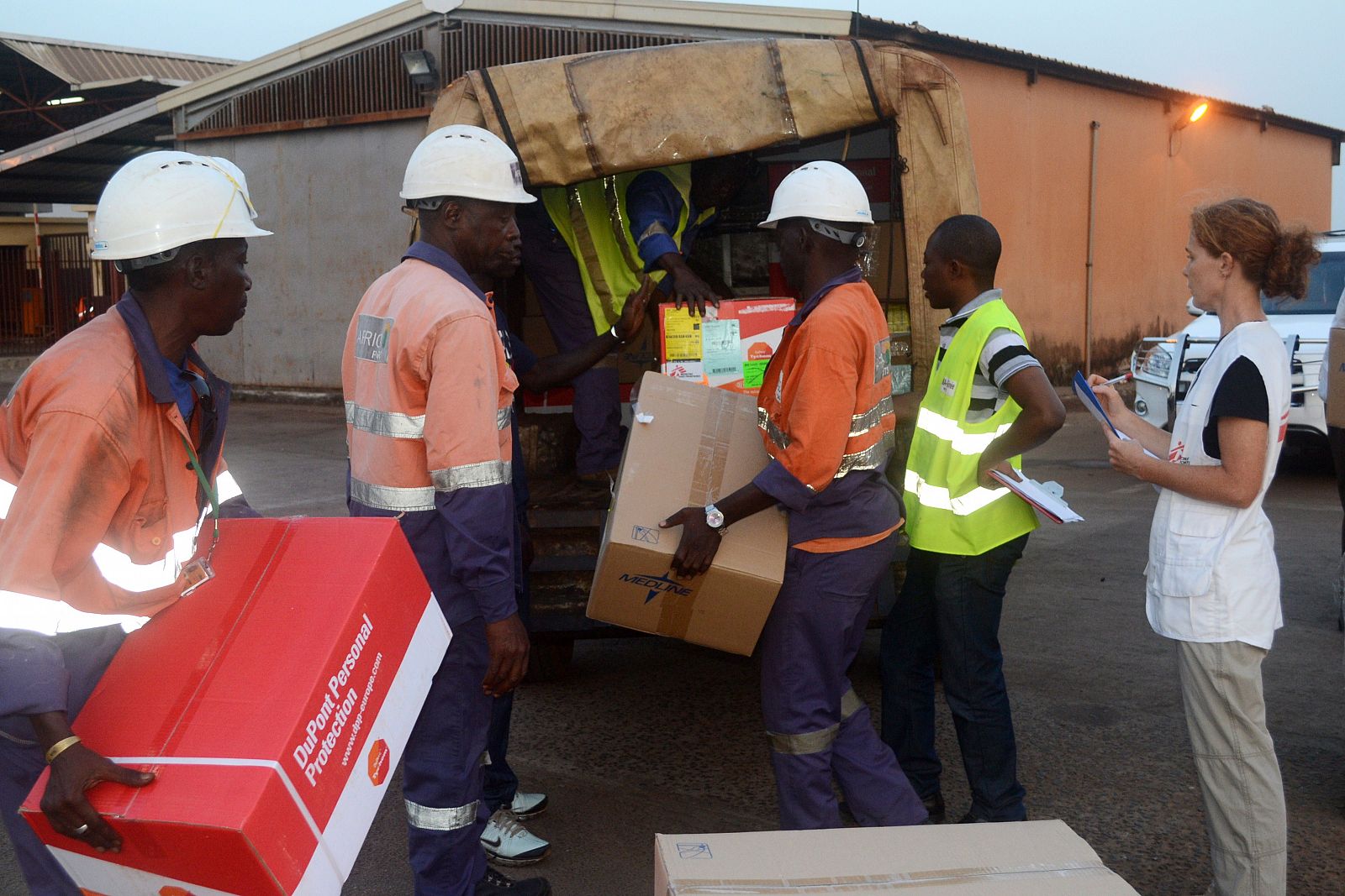 Trabajadores de Médicos Sin Fronteras recogen material en el aeropuerto de Conakry para tratar a los enfermos de ébola.