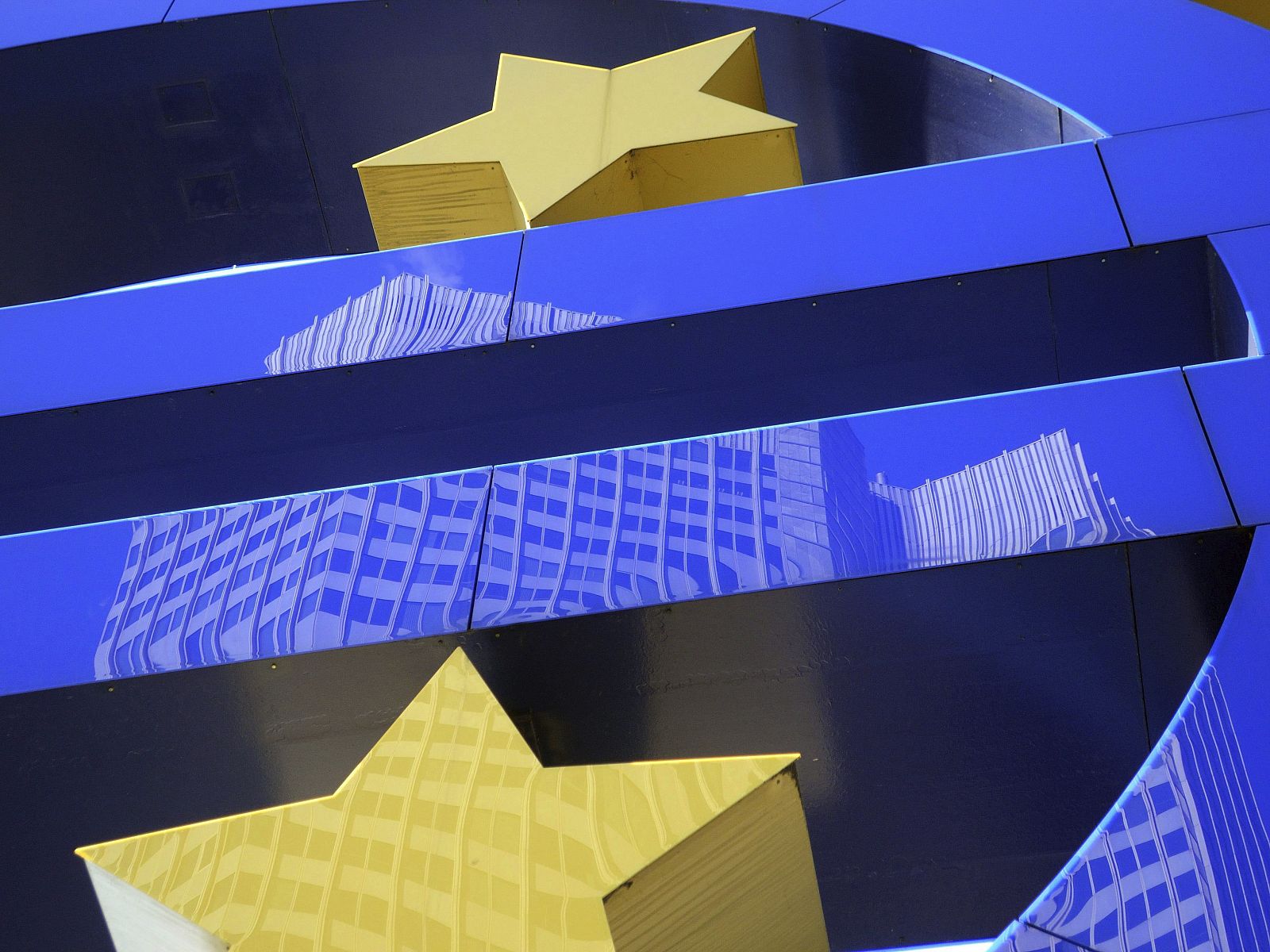 El edificio del Banco Central Europeo reflejado sobre el símbolo del euro, en Fráncfort