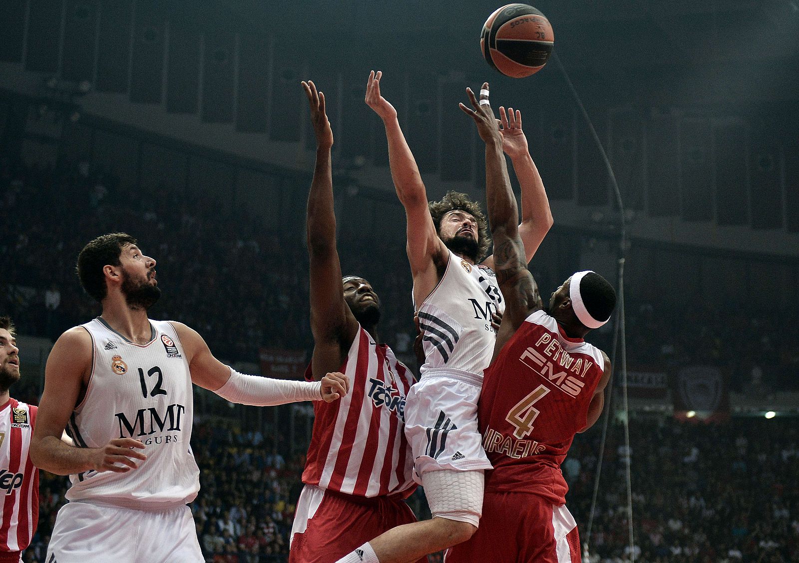 El jugador del Real Madrid Sergio Llull  (C), rodeado por jugadores del Olympiacos.