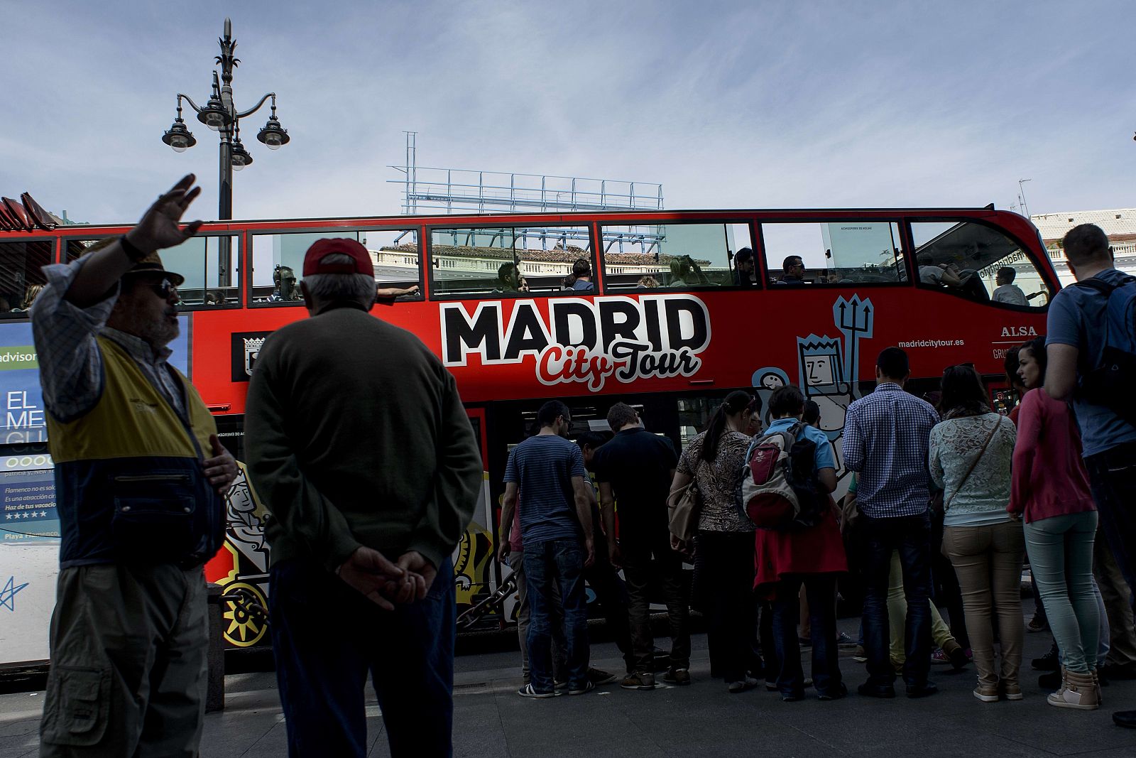 Un grupo de turistas espera para subir a un autobús turístico en Madrid