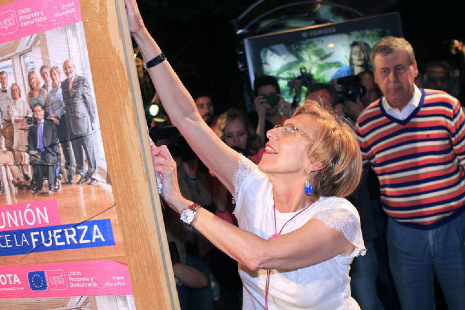 Francisco Sosa Wagner, que cambió su habitual pajarita por un jersey a rayas, observa a la líder de UPyD, Rosa Díez, en el acto de inicio de campaña. 