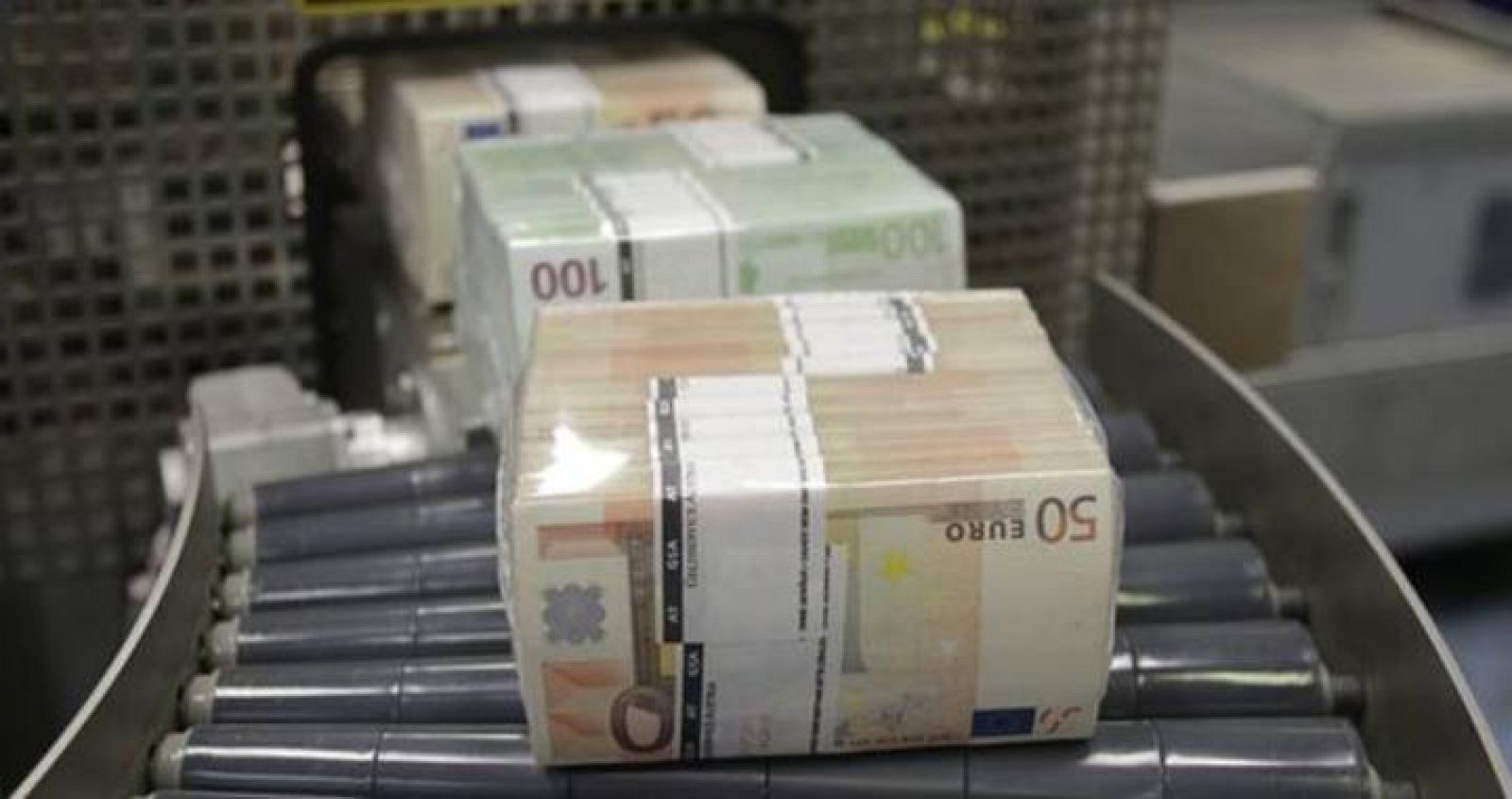 Billetes de euros saliendo de una empaquetadora