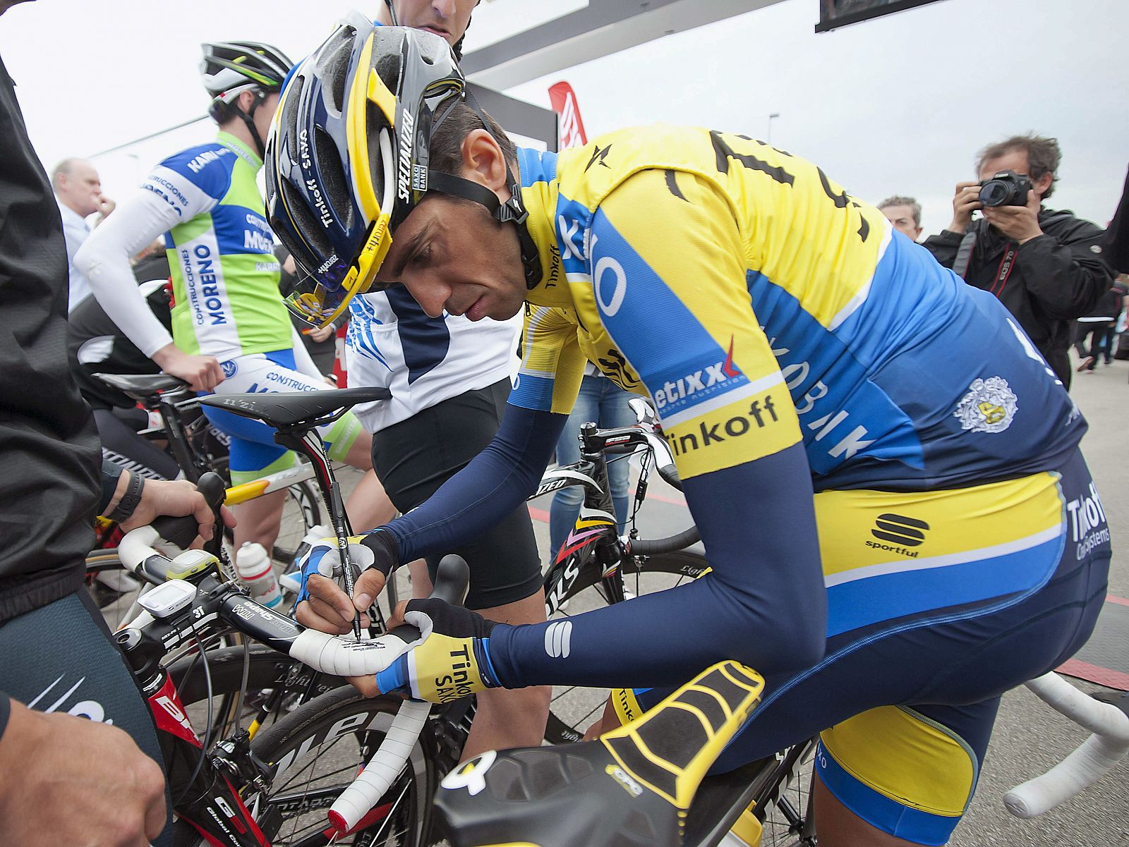 El ciclista Alberto Contador firma la bicicleta de un ciclista
