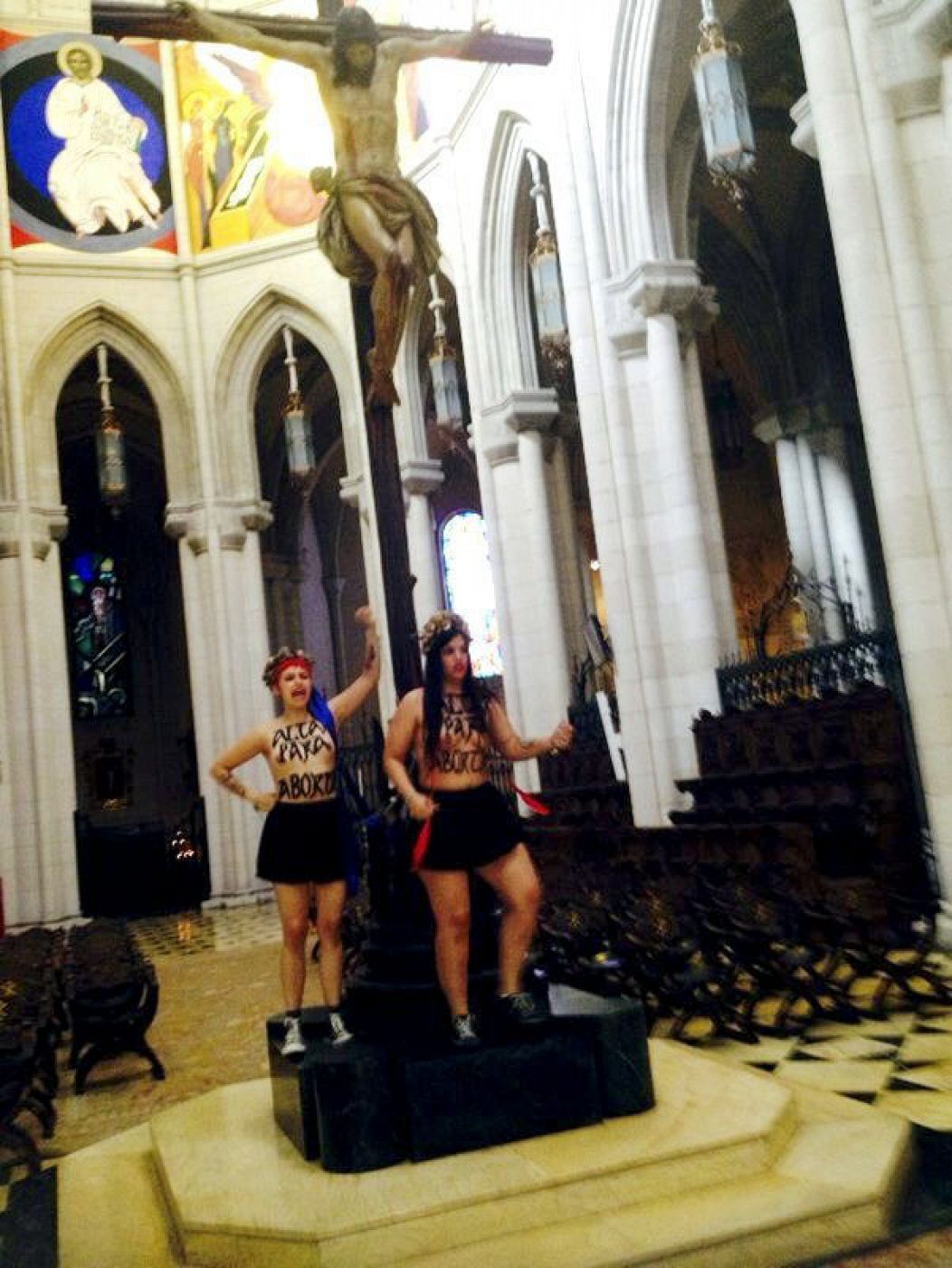 Las dos activistas de Femen encadenadas a un crucifijo en el altar de La Almudena