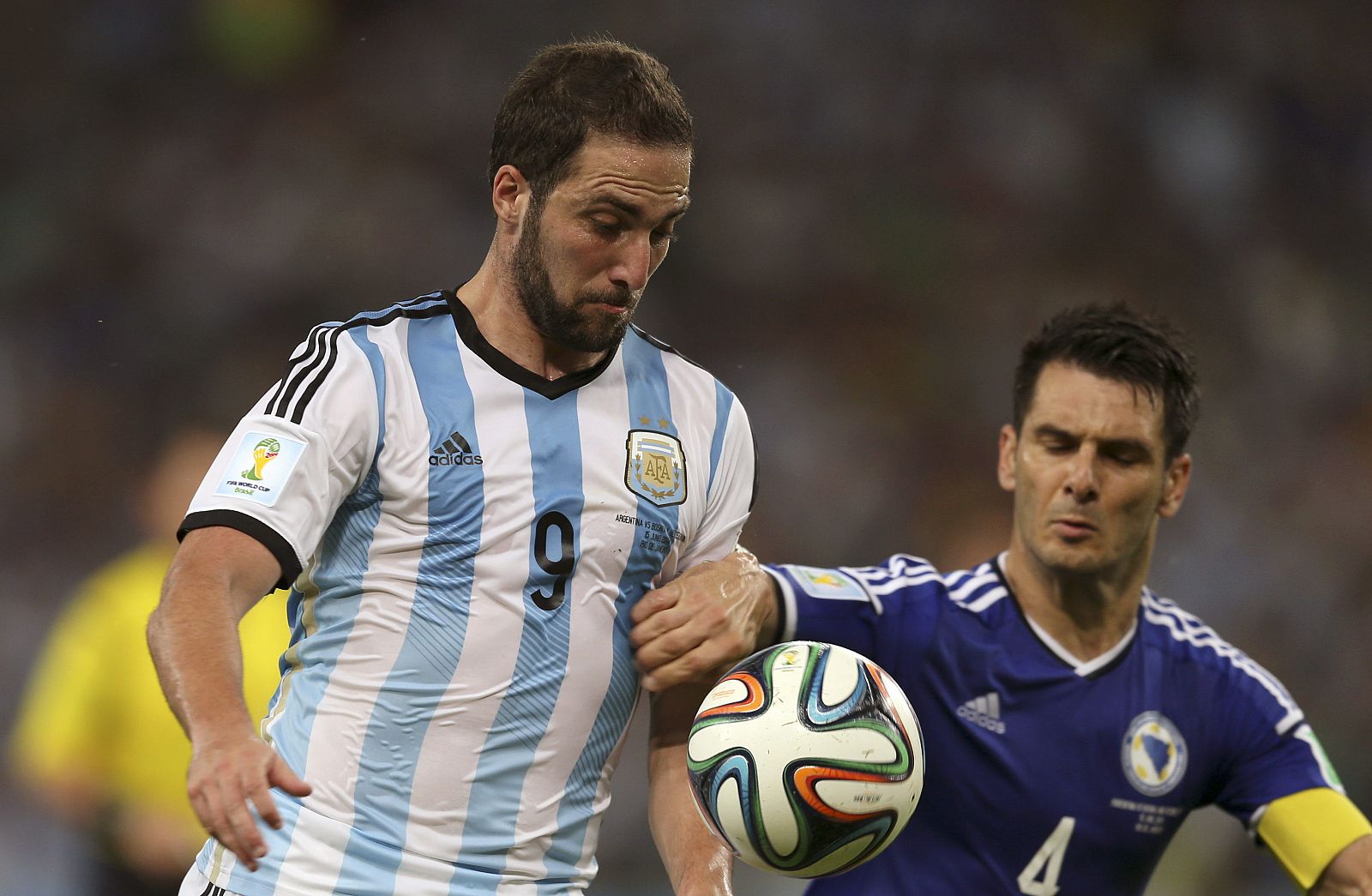 El delantero argentino Gonzalo Higuaín y el defensa bosnio Emir Spahic luchan por el balón durante el partido Argentina-Bosnia.