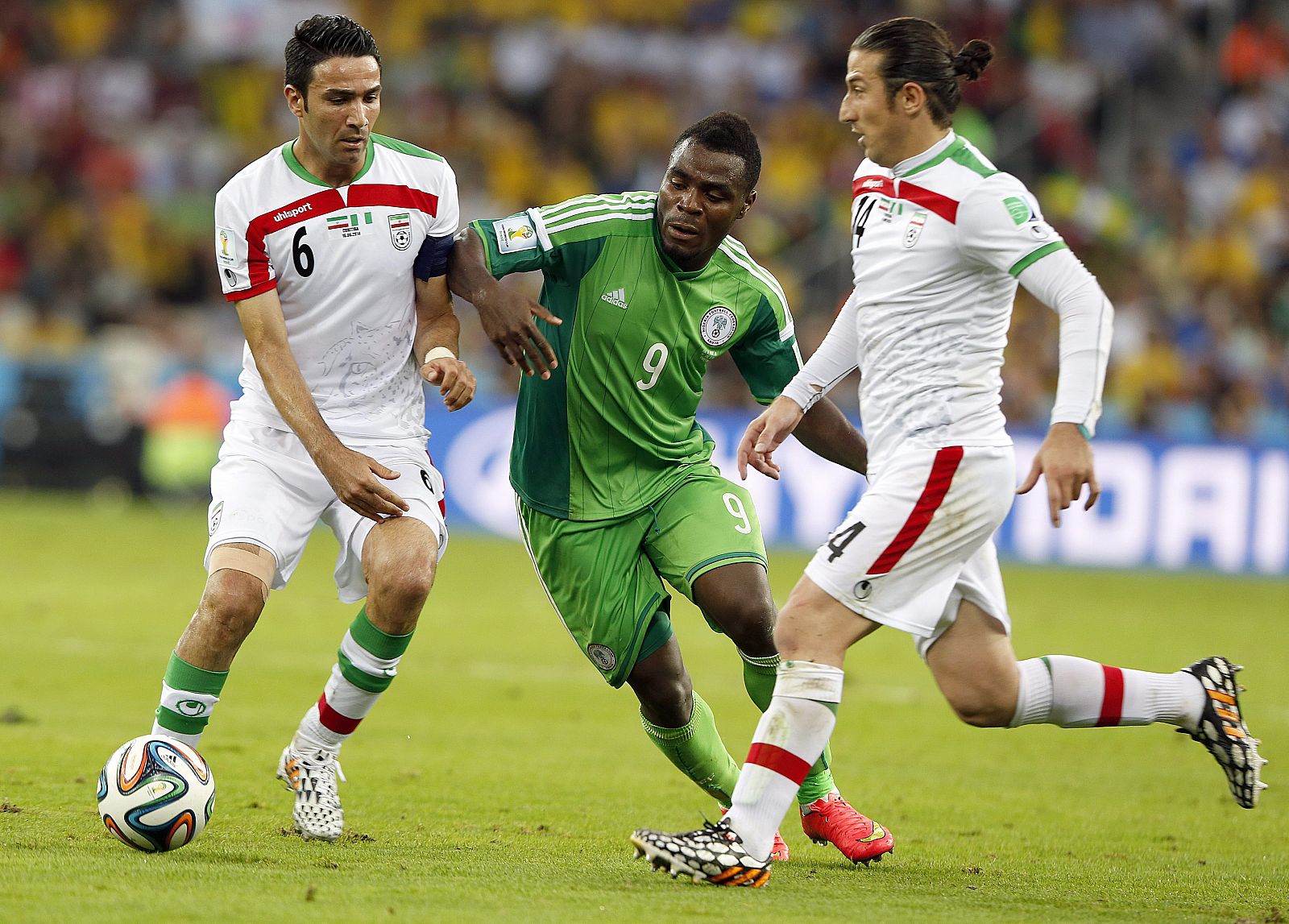 El nigeriano Emmanuel Emenike defendido por Javad Nekounam y Andranik Timotian durante el partido.