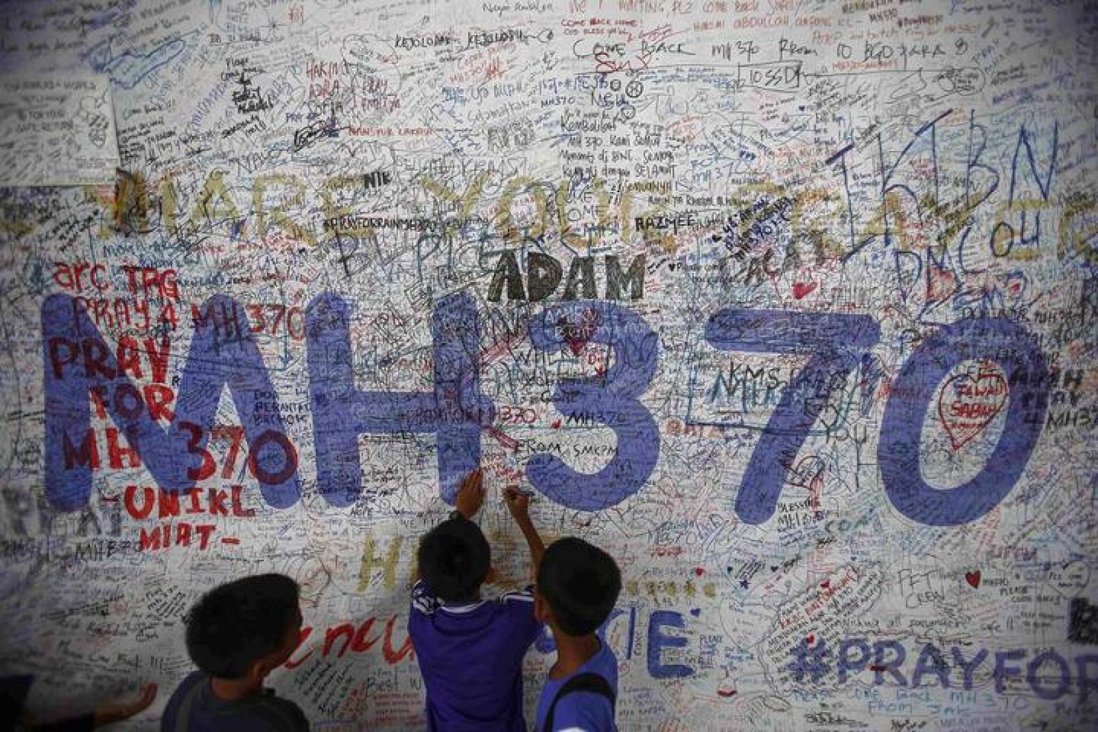 Niños escriben mensajes de esperanza para los pasajeros desaparecidos del vuelo MH370 en el aeropuerto de Kuala Lumpur. 