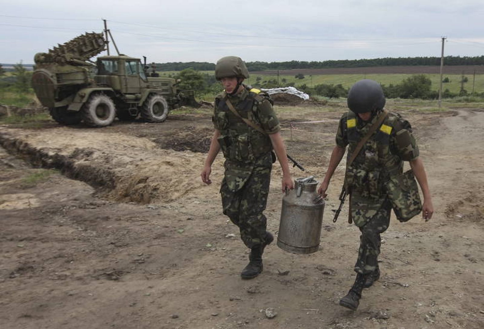 Soldados ucranianos cargan agua cerca a su campamento en Slaviansk (Ucrania)
