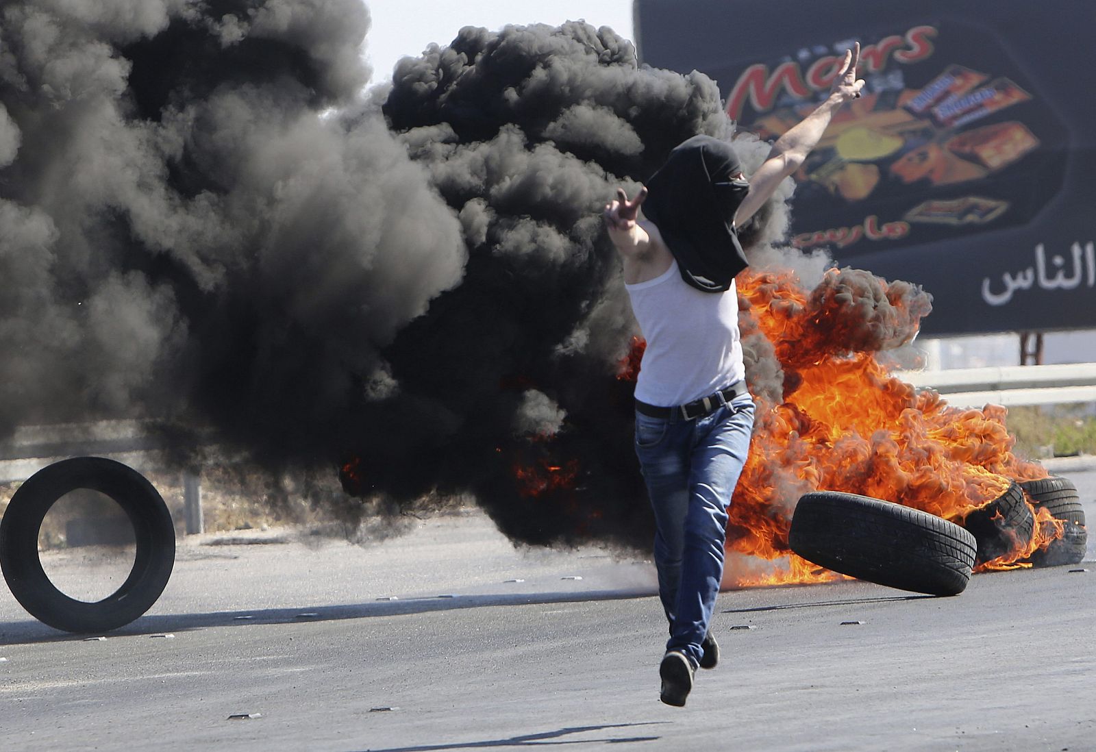 Un manifestants palestino desafía a la policía israelí durante una manifestación contra la ofensiva en Gaza en el puesto de control de Hawara, cerca de Nablus.