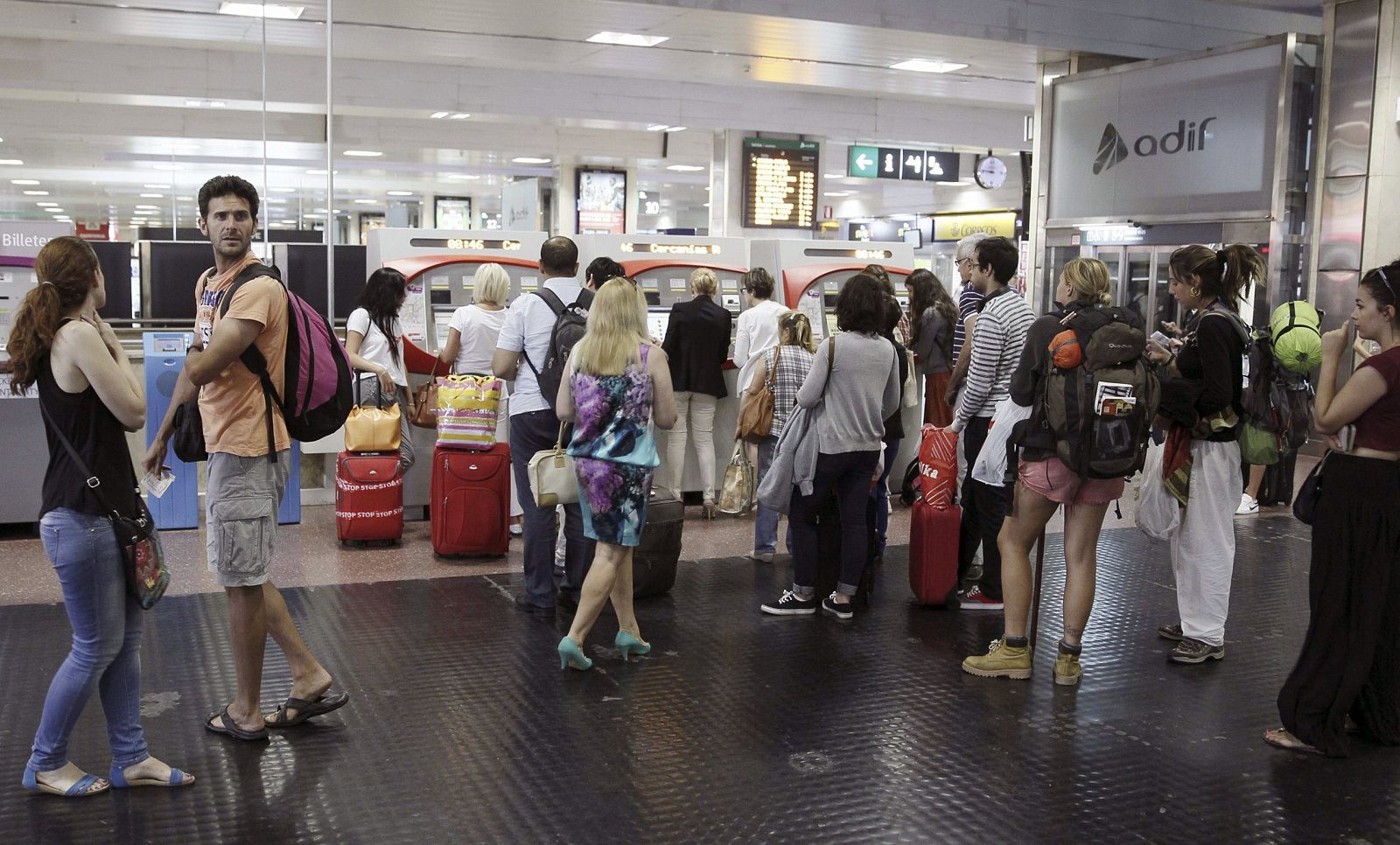 Varias personas hacen cola para comprar un billete de tren