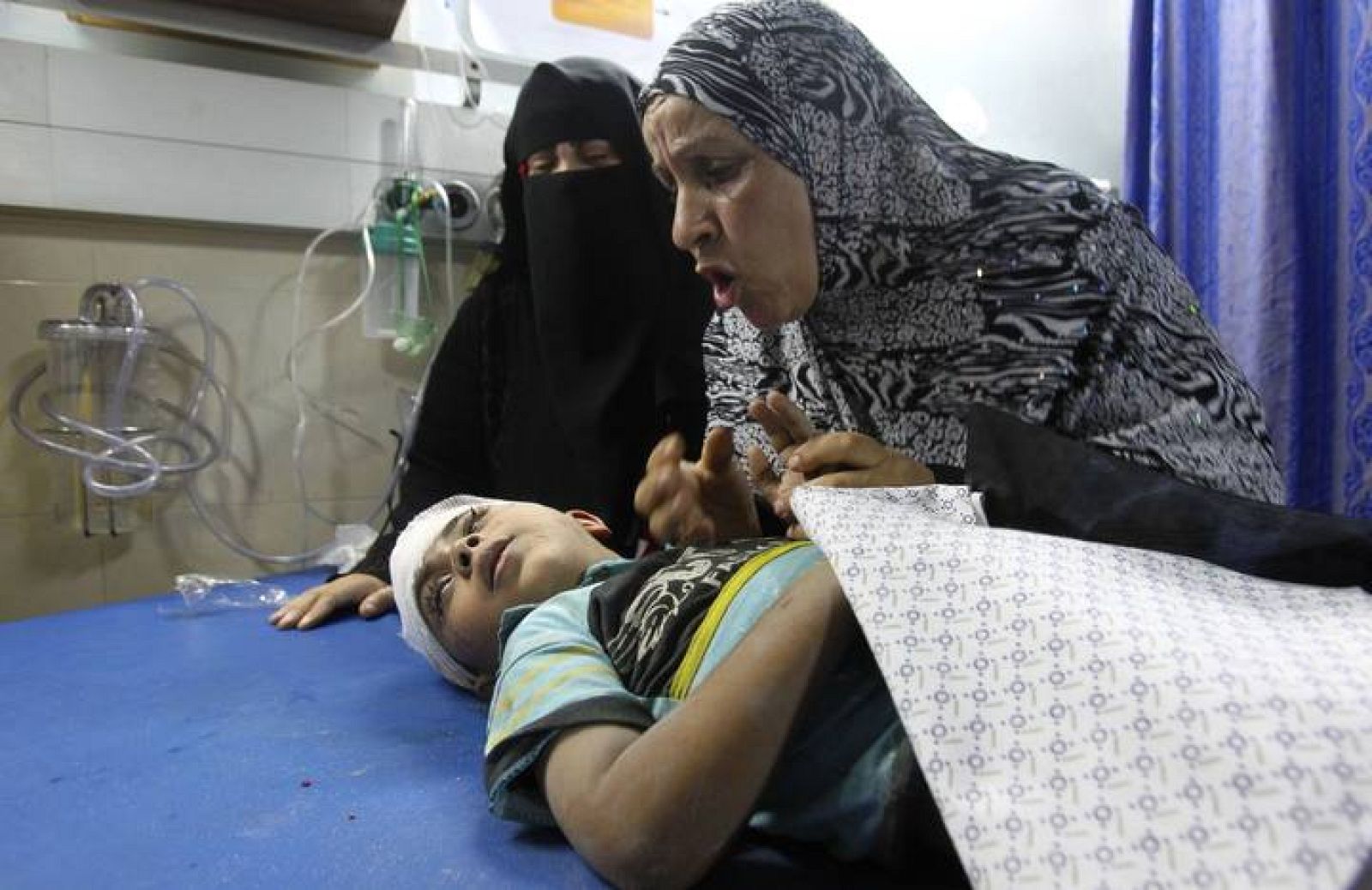 Una mujer y su hijo, herido en un ataque israelí según fuentes médicas palestinas, en el hospital de Gaza 