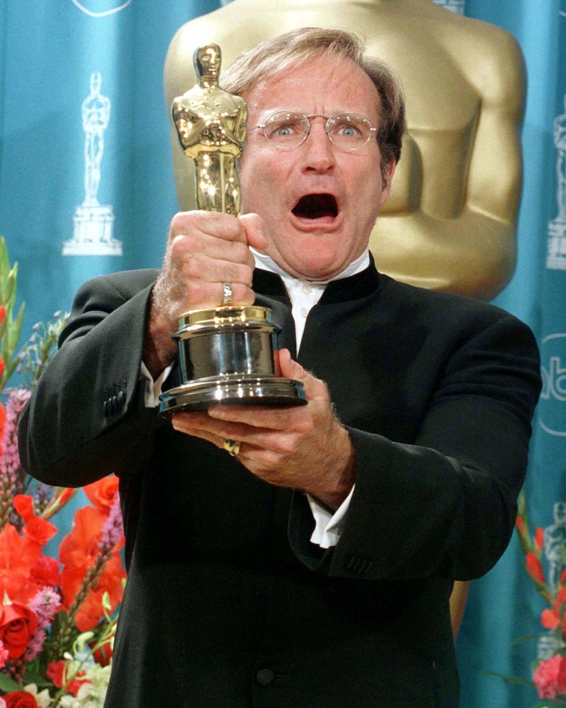 File picture shows Robin Williams holding his Oscar after winning Best Performance by an Actor in a Supporting Role at the 70th Annual Academy Awards