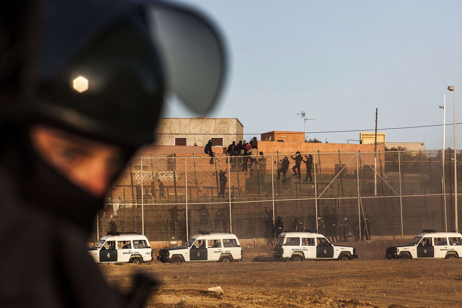 Agentes de la Guardia Civil escalan la valla fronteriza de Melilla para evitar el asalto de los inmigrantes subsaharianos