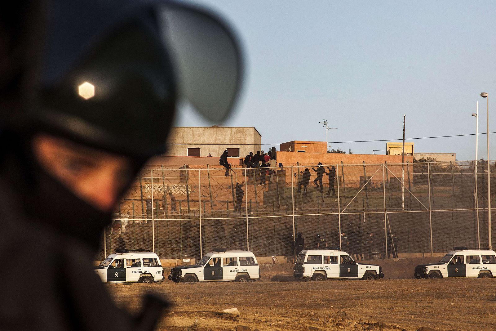 Agentes de la Guardia Civil escalan la valla fronteriza de Melilla para evitar el asalto de los inmigrantes subsaharianosia civil