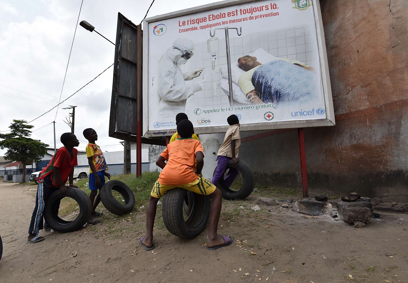 Unos niños observan un cartel que advierte del peligro del ébola en Abiyán, Costa de Marfil.