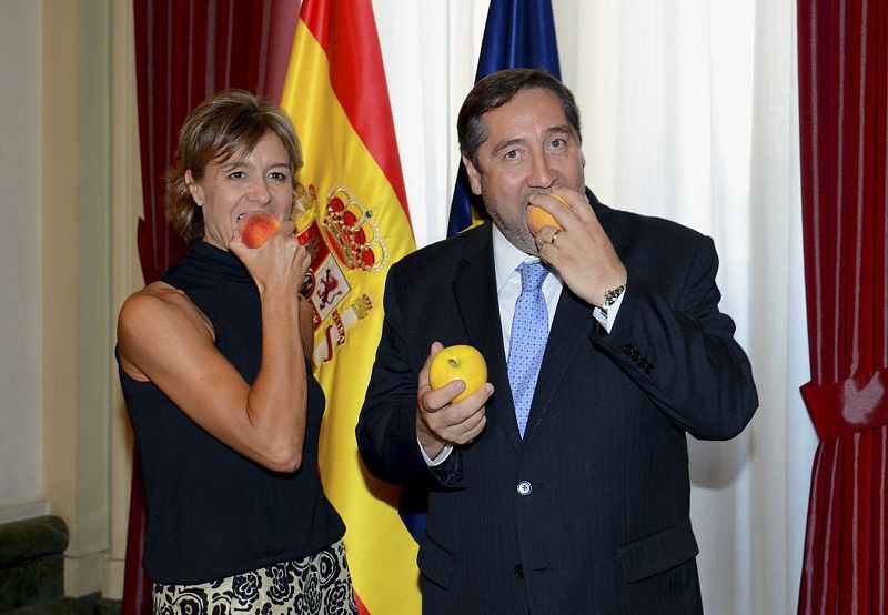 La ministra de Agricultura, Alimentación y Medio Ambiente, Isabel García Tejerina, y el consejero catalán de Agricultura, Josep María Pellegrí, posan juntos ante las cámaras comiendo fruta, para promover su consumo