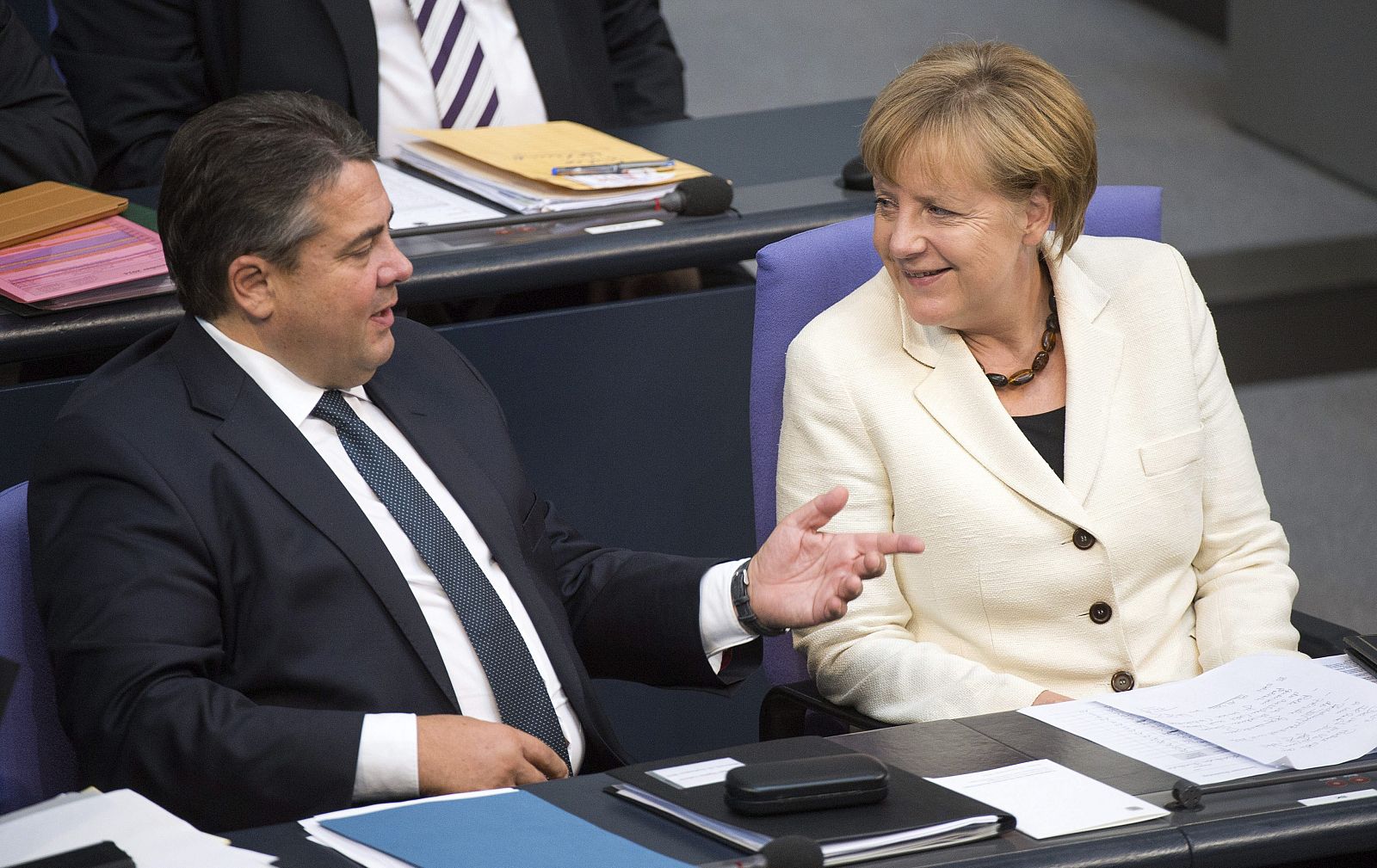 La canciller alemana, Angela Merkel, conversa con el ministro de Economía, Sigmar Gabriel, durante el debate de política general en el Bundestag en Berlín