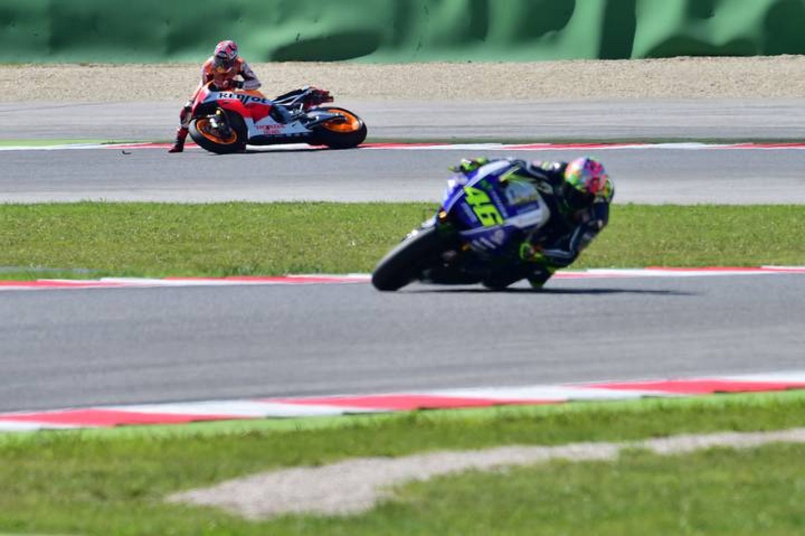 Rossi lidera la carrera con Márquez, al fondo, fuera de pista