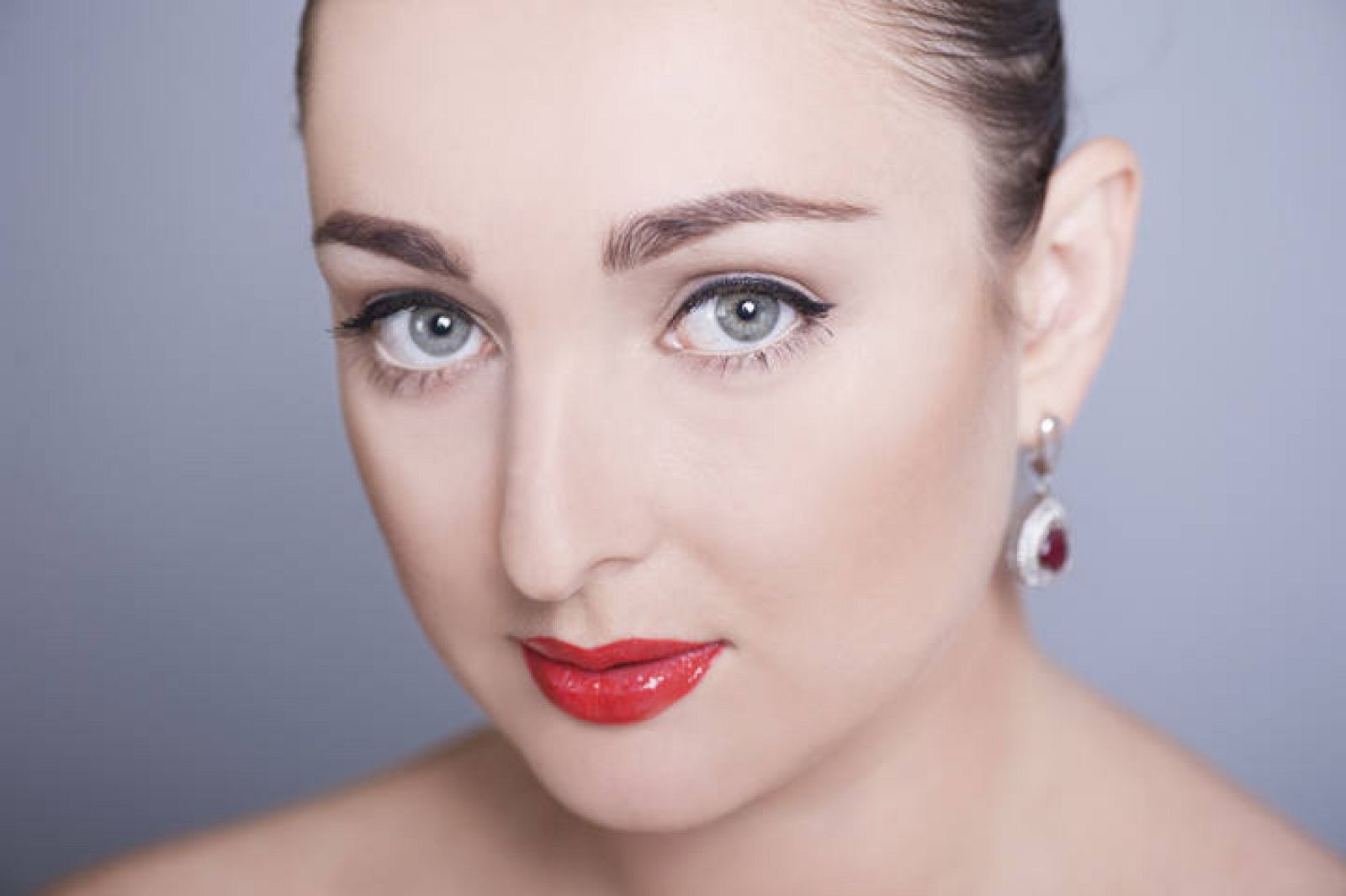  Una mujer con los labios pintados con carmín rojo.