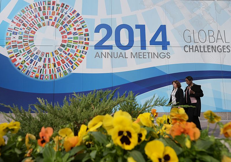 Dos mujeres pasan por delante del anuncio de la reunión anual del FMI en Washington