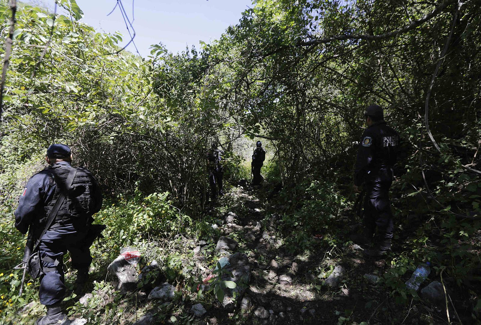 Iguala police officers stand guard at an area near clandestine graves at Pueblo Viejo, in the outskirts of Iguala, southern Mexican state of Guerrero