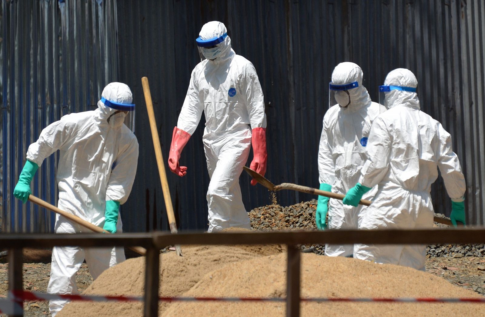 Trabajadores sanitarios recogen arena para absorber los fluidos de pacientes infectados con ébola en Sierra Leona.