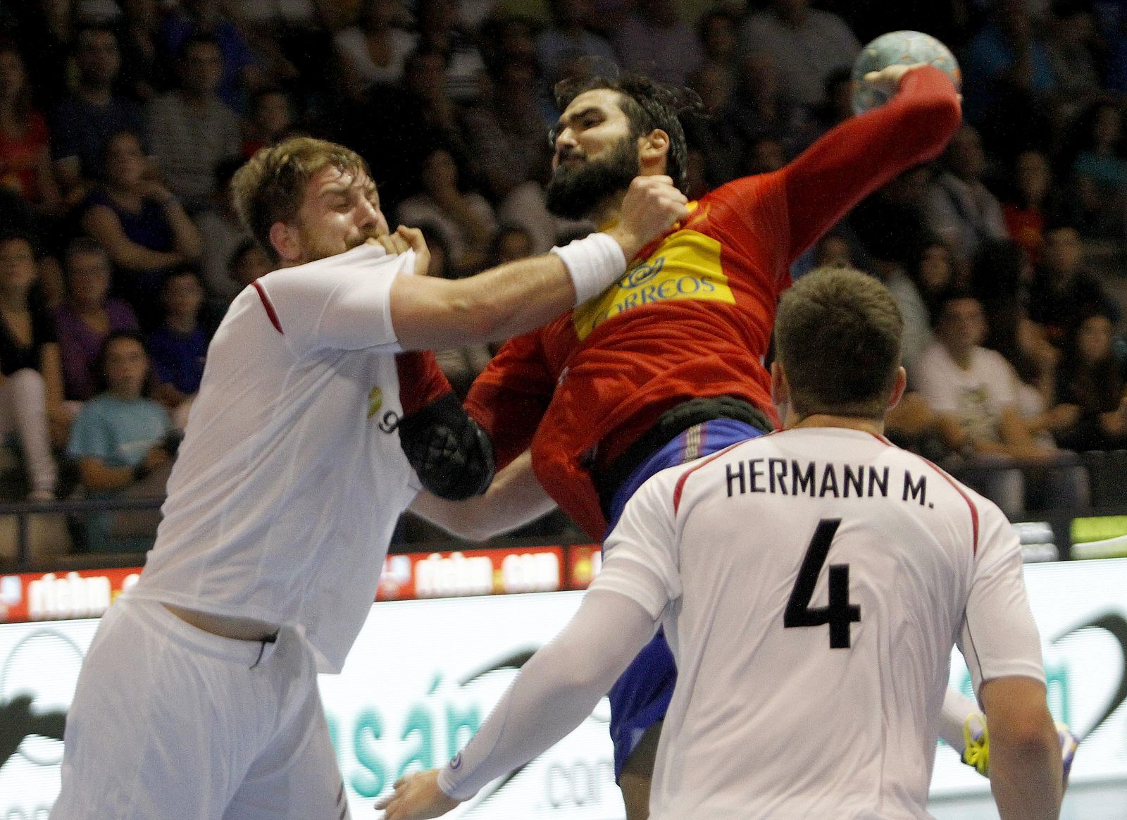 El jugador de la selección española, Maqueda (2i), intenta lanzar ante la defensa del jugador de la selección de Austria, Schlinger (i)