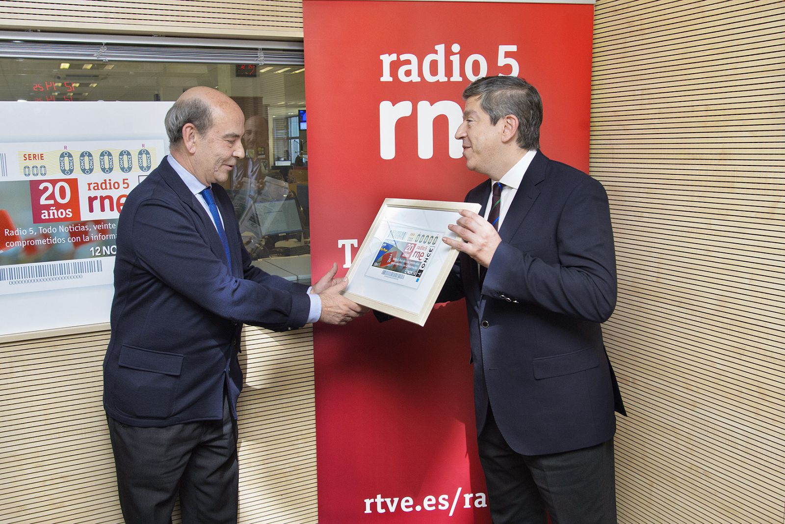 El director de RNE, Alfonso Nasarre, recibe el cupón conmemorativo de manos de Antonio Mayor, director de Comunicación e Imagen de la ONCE.