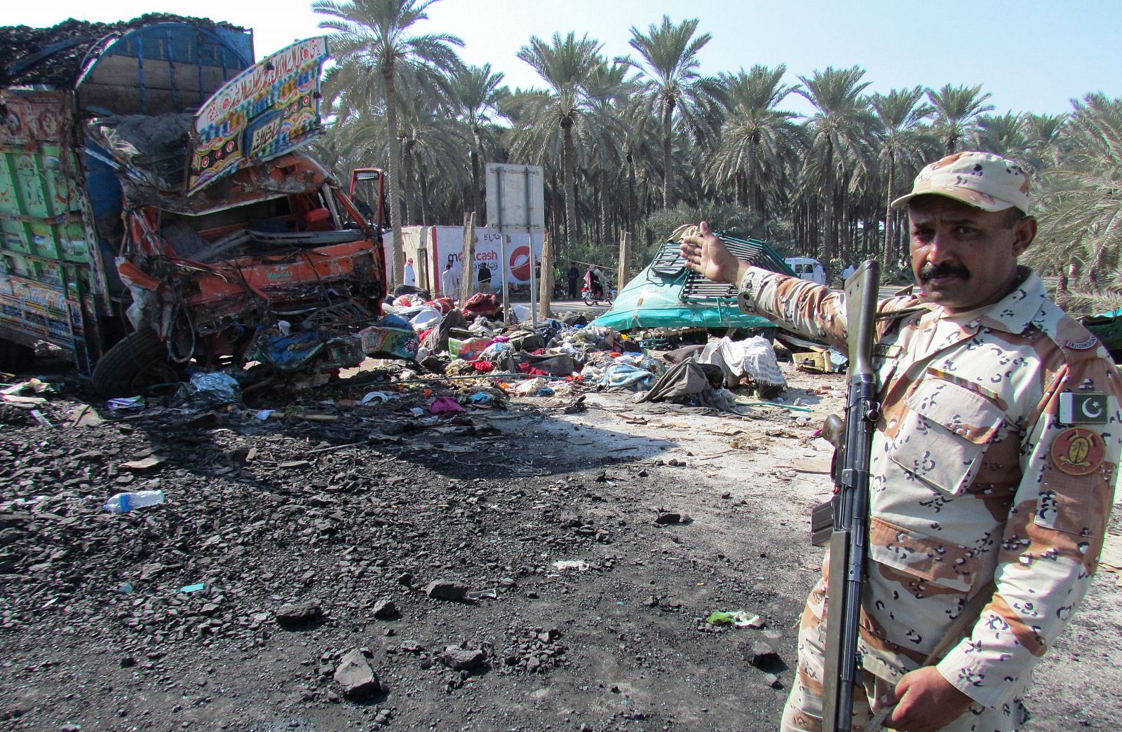 Un policía paquistaní señala el lugar del accidente de autobús cerca de Jairpur