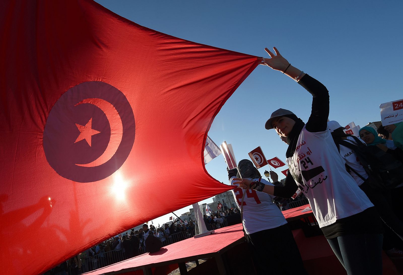 Dos tunecinas extienden una bandera del país durante un acto electoral
