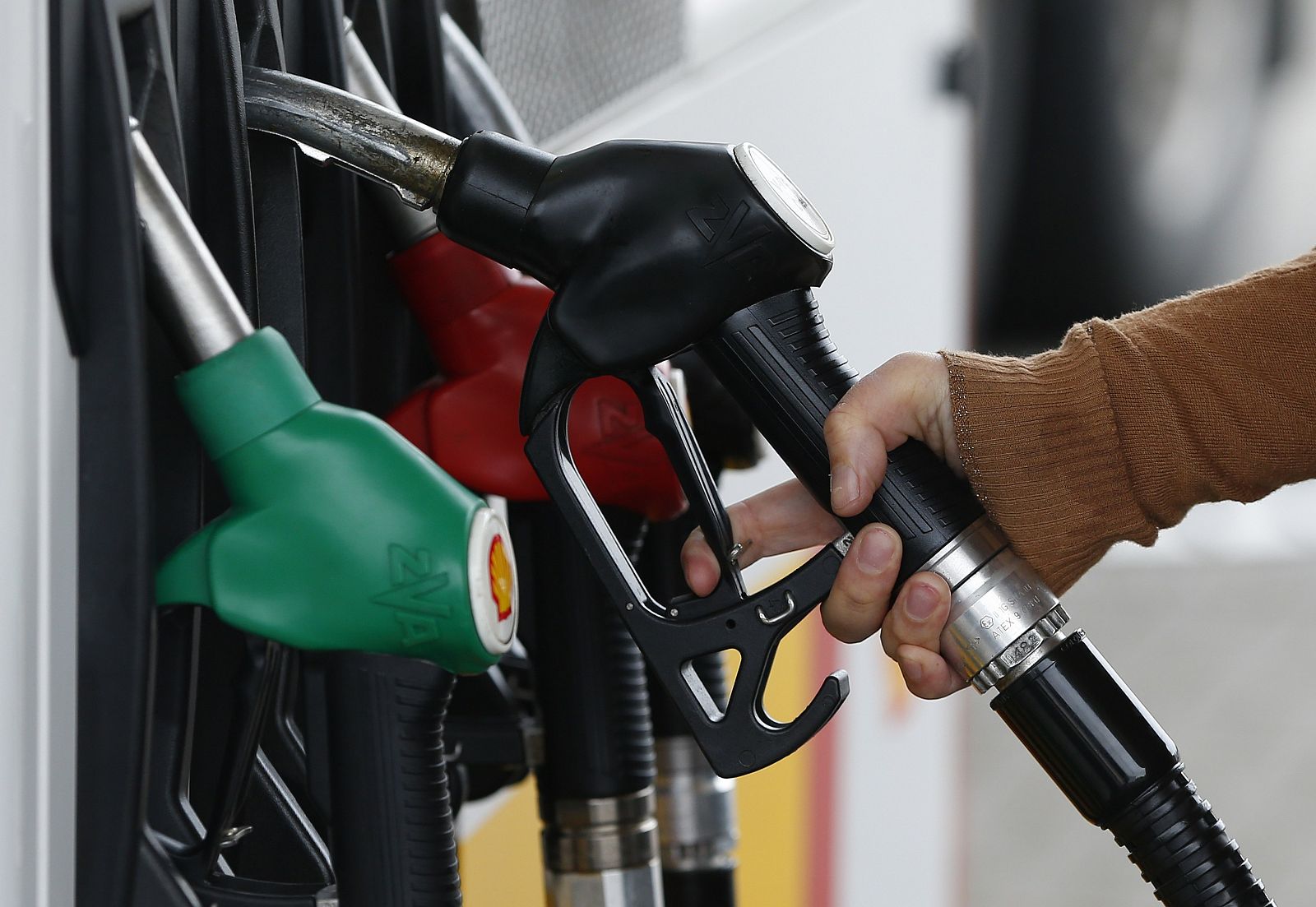 Un cliente reposta combustible en una gasolinera