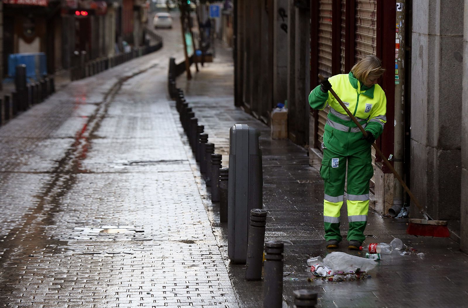 Una trabajadora de los Servicios de Limpieza de Madrid recoge basura