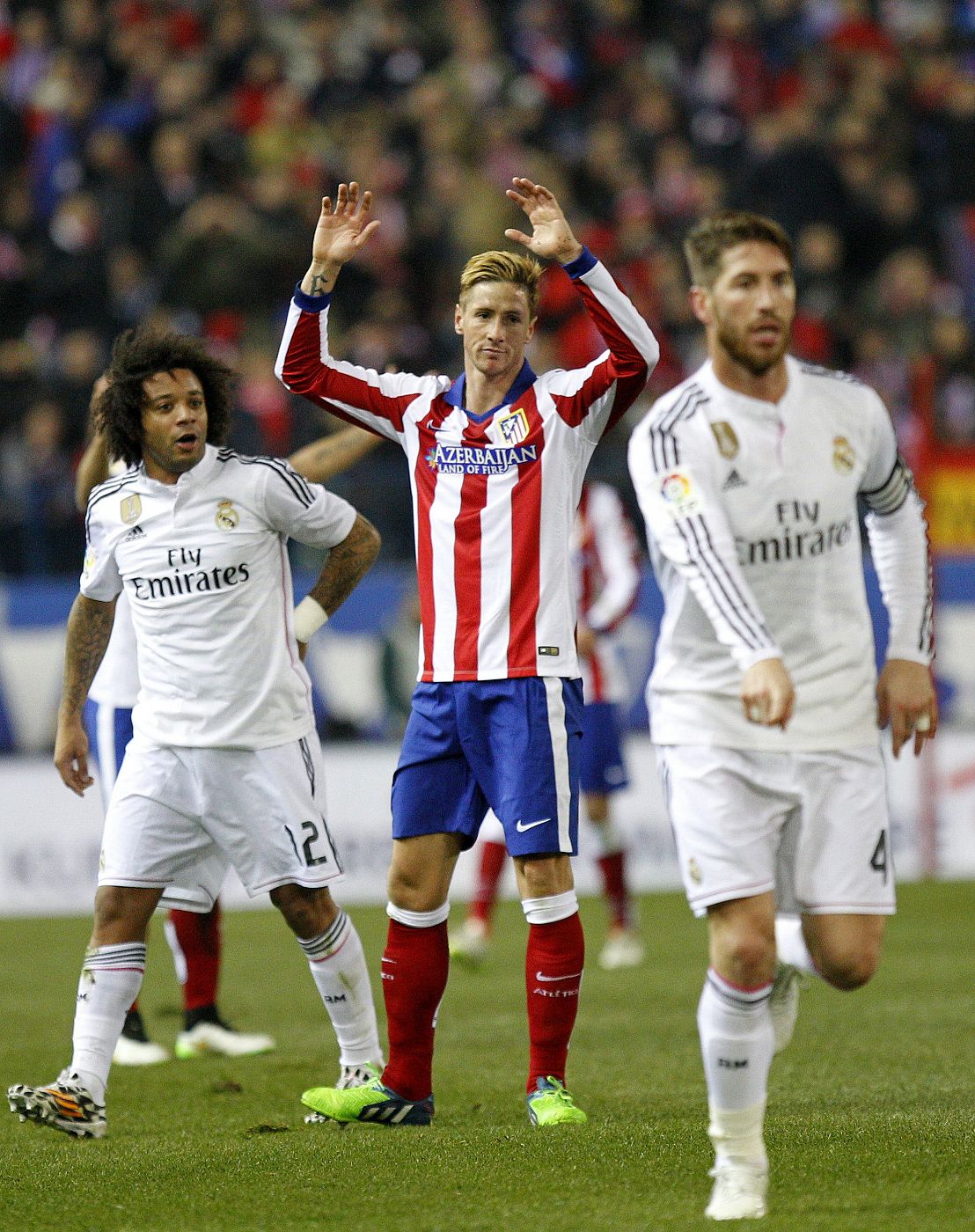 El delantero del Atlético Fernando Torres (c) protesta ante Sergio Ramos (d) y Marcelo (i).