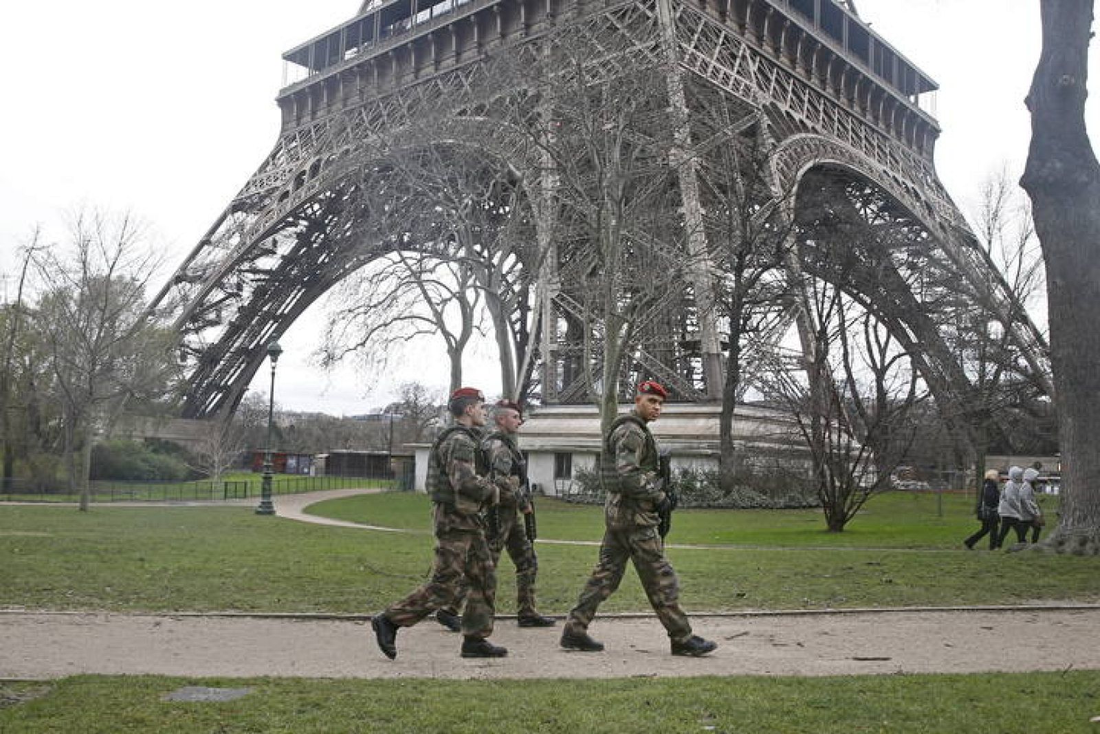 Varios soldados pasean cerca de la Torre Eiffel, en París (Francia).  