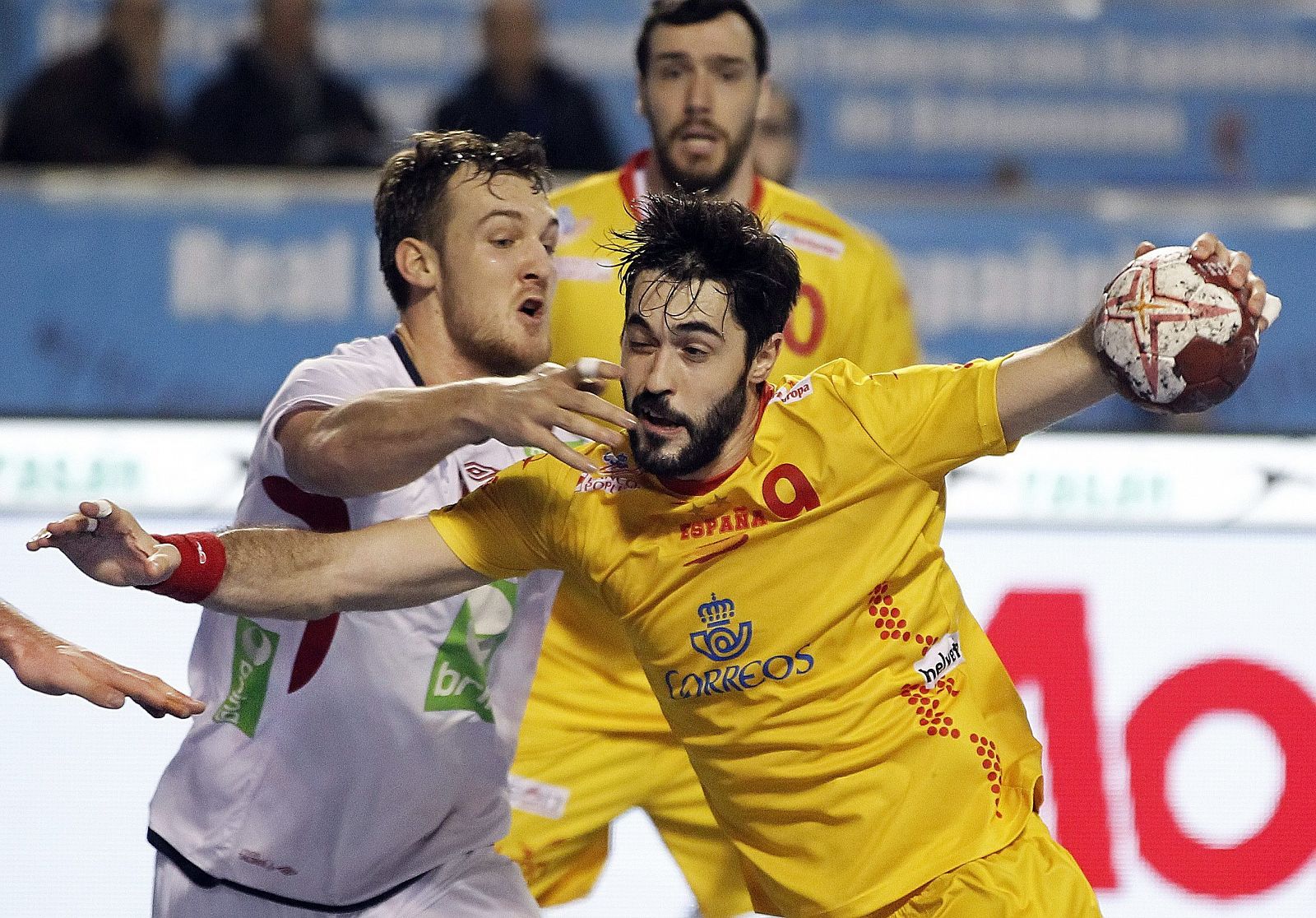 El jugador de la selección española de balonmano Raúl Entrerríos (d) se dispone a lanzar ante Kristian Bjornsen, de Noruega