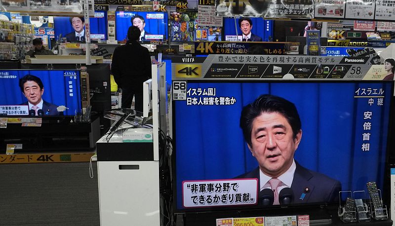 Un hombre observa al primer ministro Shizo Abe informando desde Jerusalén del secuestro de dos japoneses por el Estado Islámico.