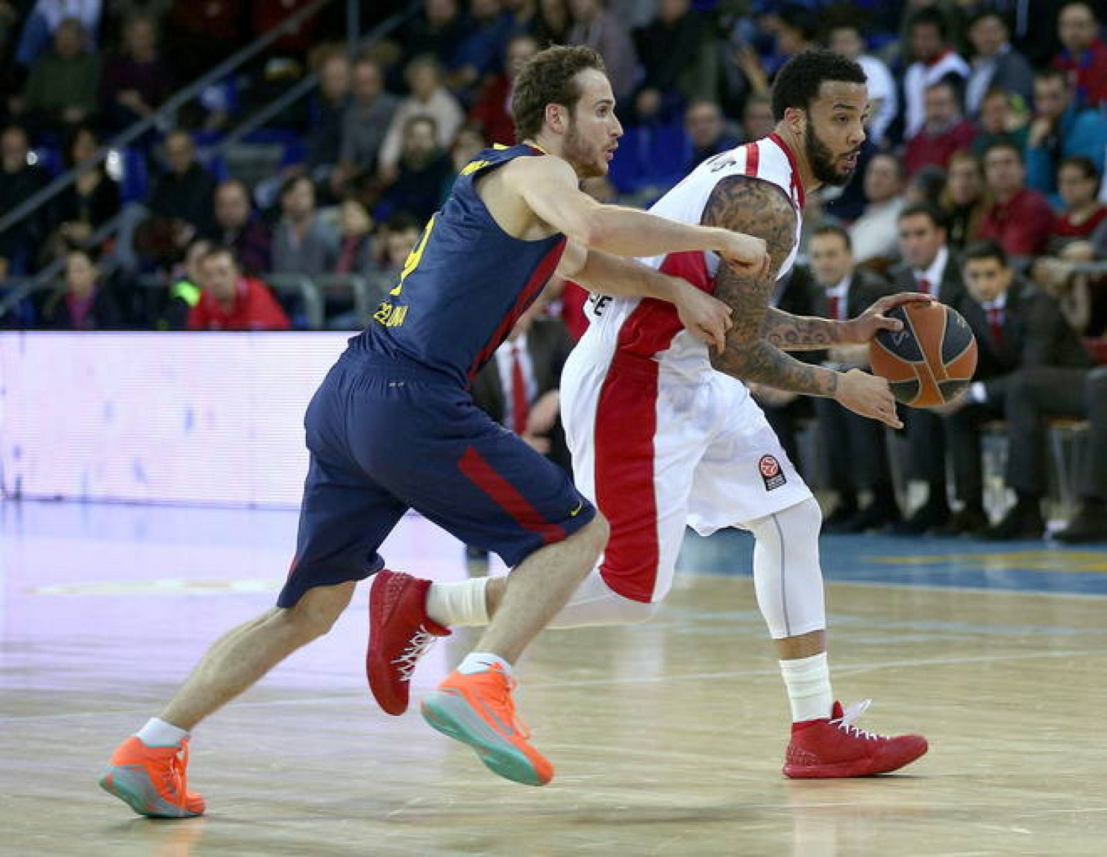 El base estadounidense del Estrella Roja de Belgrado Marcus Williams (d) controla el balón ante la presión de Marcelinho Huertas