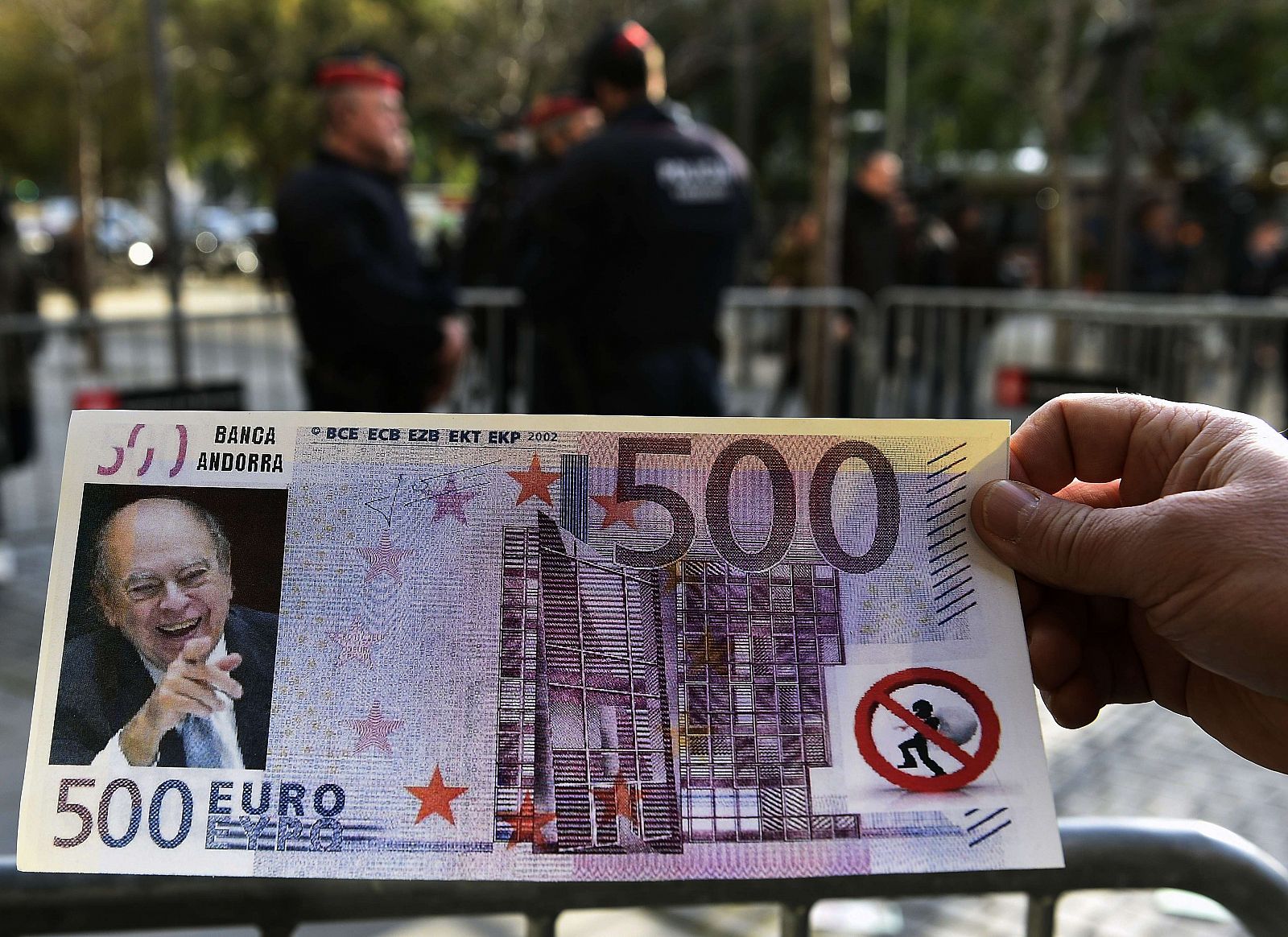 Una persona sostiene un billete falso de 500 euros con la imagen del expresidente de la Generalitat, Jordi Pujol, que le arrojaron en el juzgado en Barcelona.