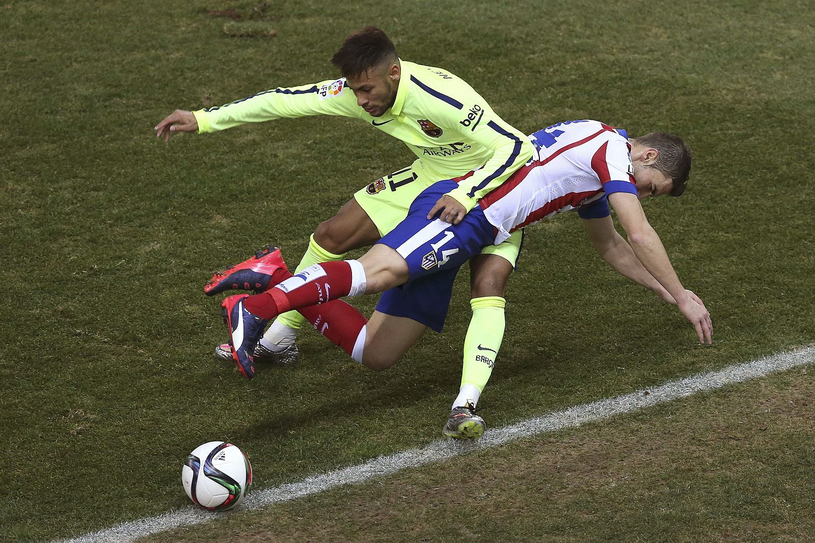 El centrocampista del At. de Madrid, Gabi (d), cae ante la entrada del delantero brasileño del F. C. Barcelona, Neymar