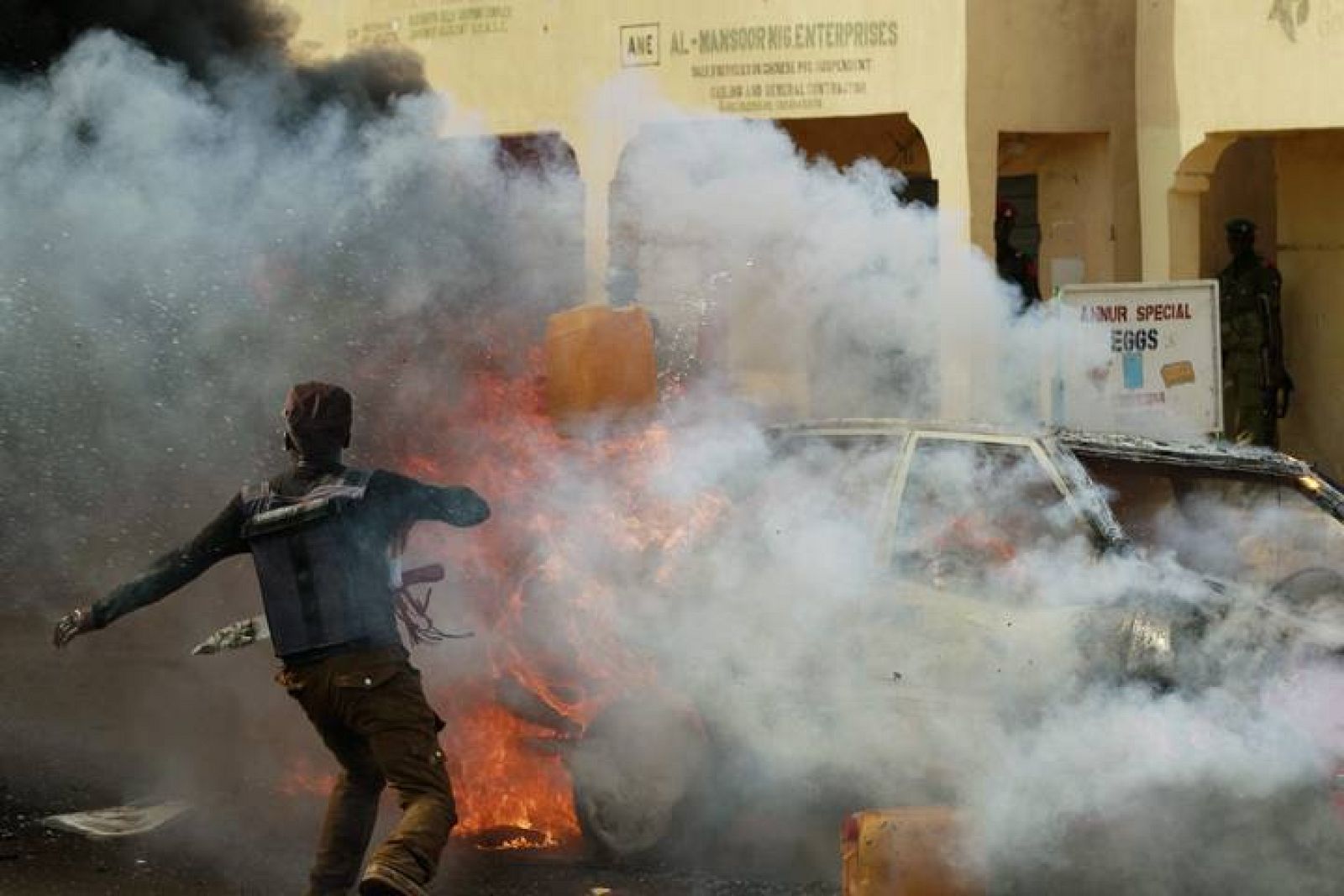 Un hombre intenta apagar las llamas del coche bomba en el estadio de Gombe, Nigeria. 