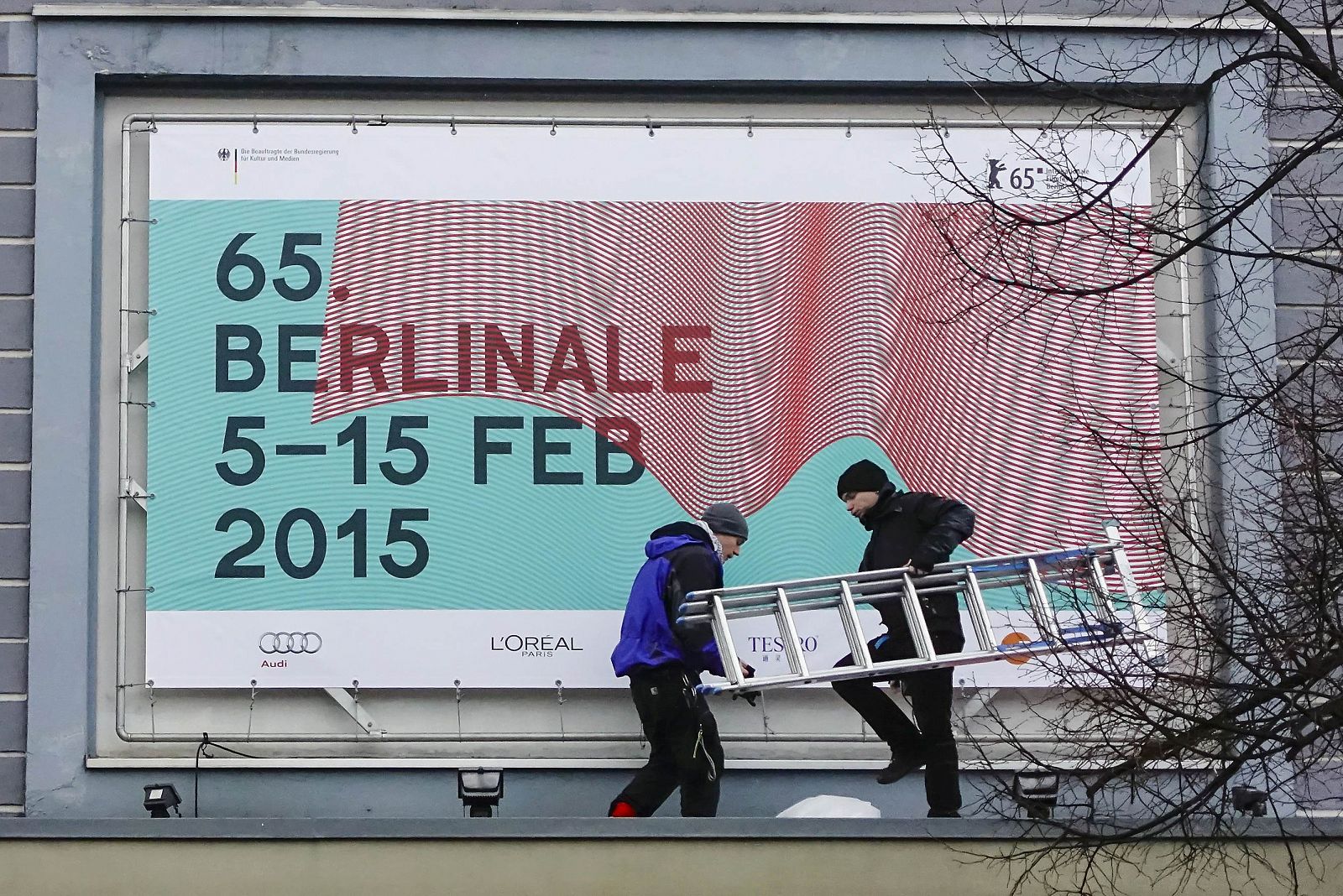 Trabajadores instalando un cartel de la 65 edición de la Berlinale