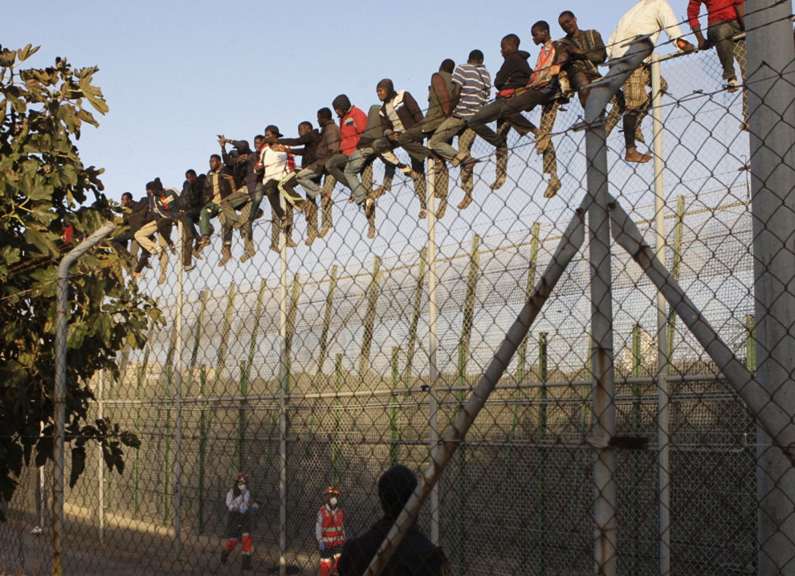 Decenas de inmigrantes encarmados a la valla de Melilla, en una imagen del pasado mes de octubre.