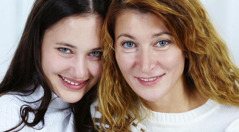 Madre e hija mirando a cámara.