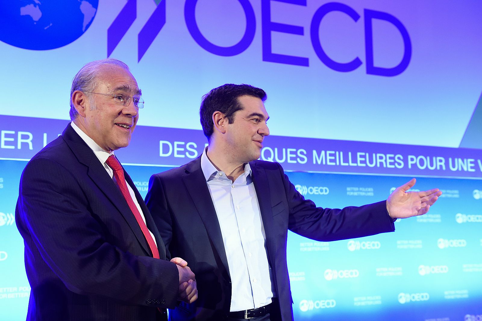 El secretario de la OCDE, Ángel Gurría, da la mano al primer ministro griego, Alexis Tsipras