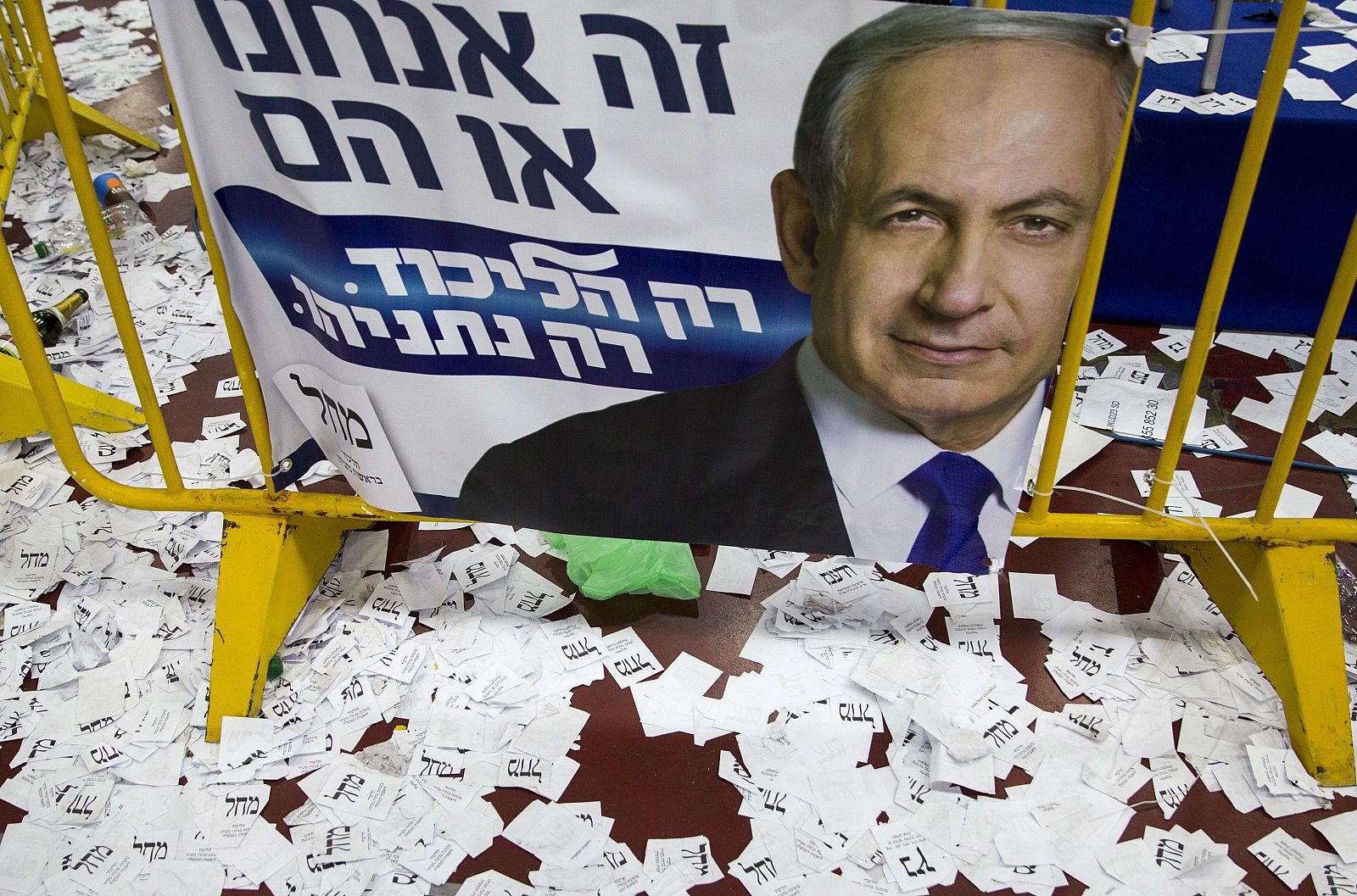 Papeletas electorales frente a un cartel de Benjamín Netanyahu, en Tel Aviv, Israel