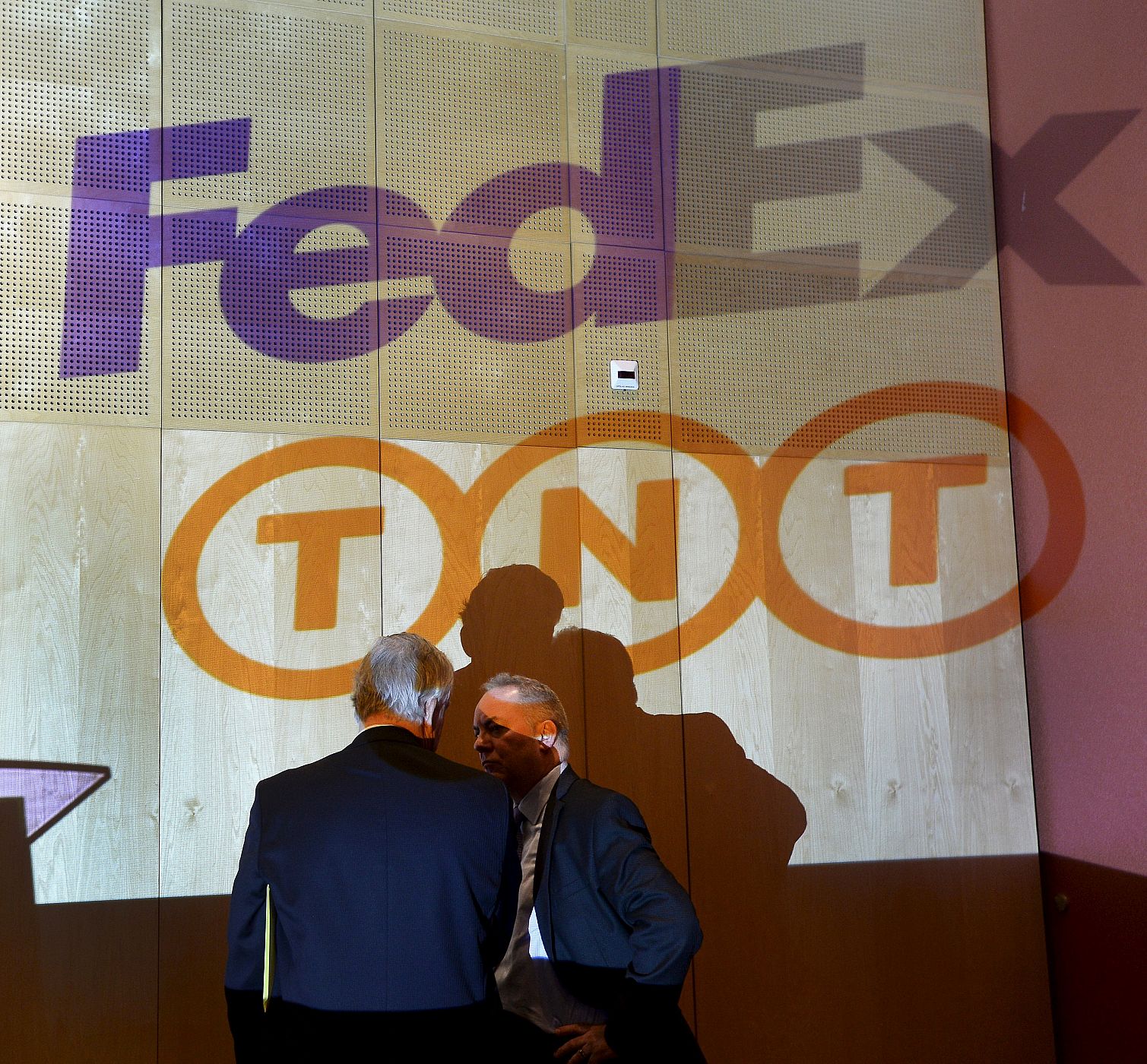 Logotipos de FedEx y TNT expuestos en la rueda de prensa que han ofrecido los presidentes de ambas compañías