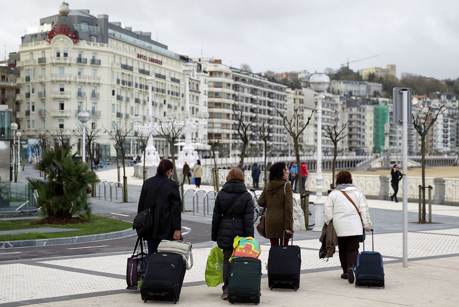 Unos turistas caminan por el paseo de la Concha en San Sebastián