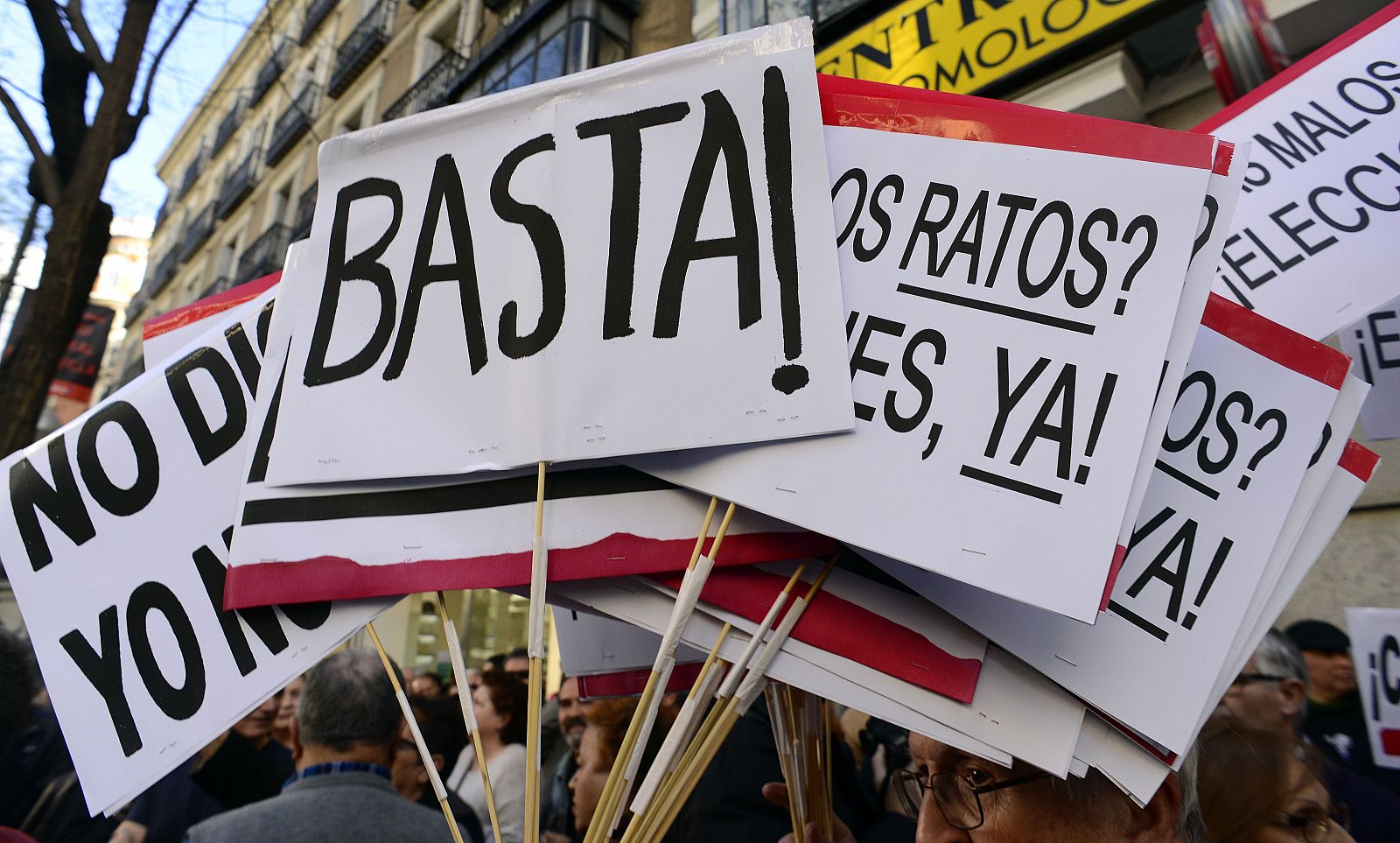 Detalle de varias pancartas enarboladas por los participantes en la concentración frente a la sede del PP por la detención de Rodrigo Rato.